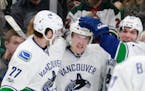 Vancouver players celebrate after Brock Boeser (6), during his first day and game for Vancouver, scored on Minnesota Wild goalie Darcy Kuemper during 