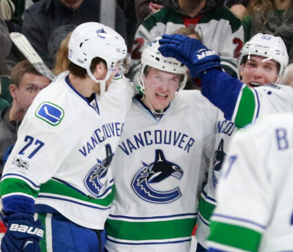 Vancouver players celebrate after Brock Boeser (6), during his first day and game for Vancouver, scored on Minnesota Wild goalie Darcy Kuemper during 