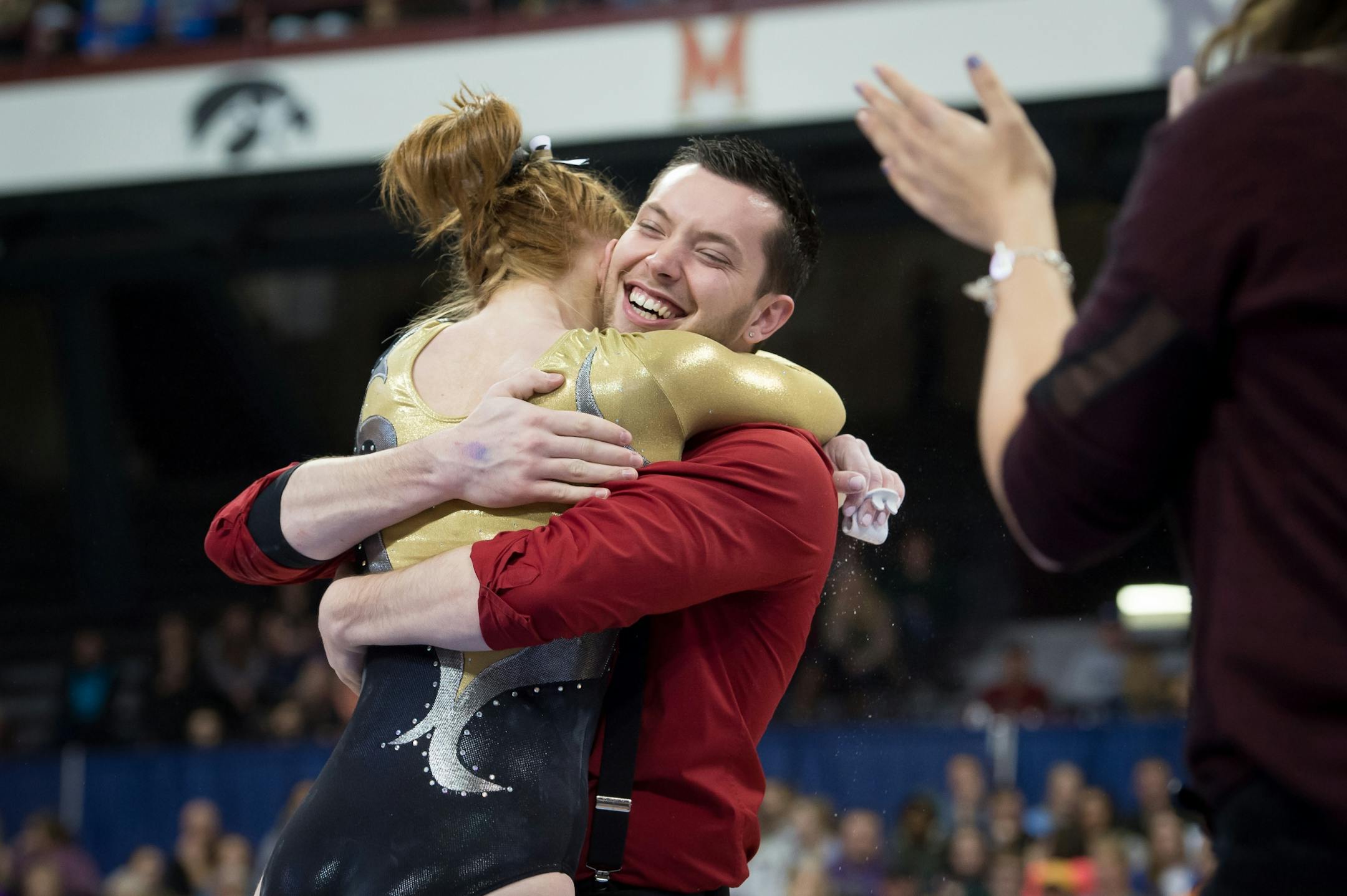 Megan Trollen of East Ridge hugs her coach, Chris Muras, after her performance on the uneven parallel bars at the gymnastics state meet on Saturday at the University of Minnesota.