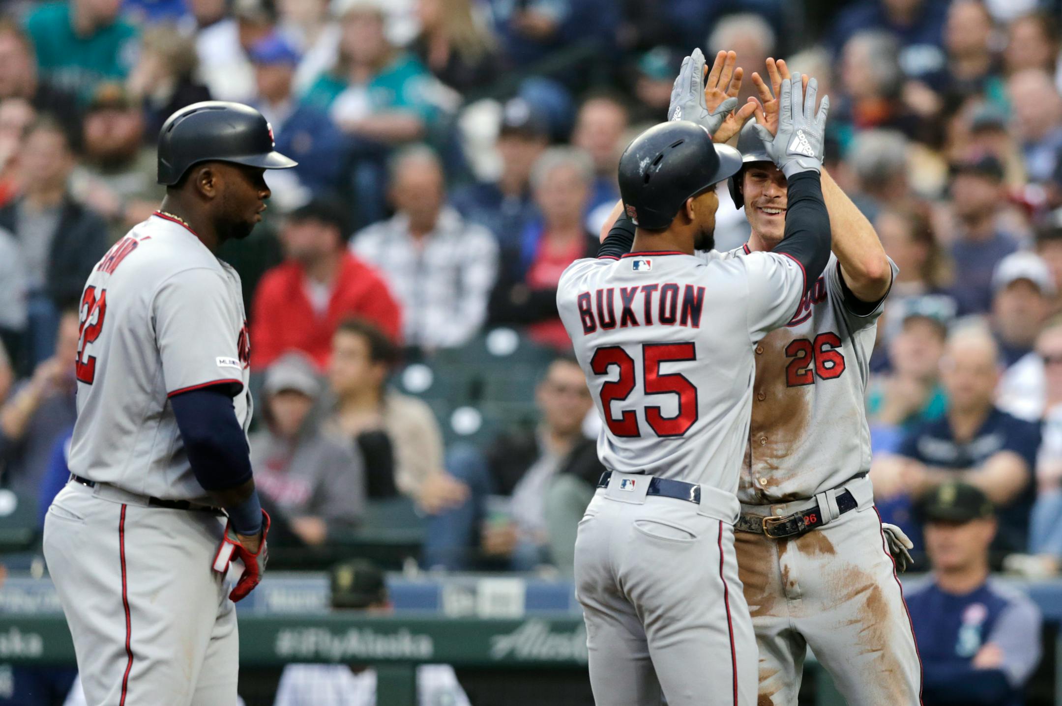 Minnesota Twins' Byron Buxton, is greeted at home plate by Max Kepler with Miguel Sano on the left after hitting a grand slam off Seattle Mariners' Wade LaBlanc during the second inning of a baseball game Saturday, May 18, 2019, in Seattle. (AP Photo/John Froschauer)