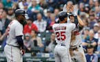 Minnesota Twins' Byron Buxton, is greeted at home plate by Max Kepler with Miguel Sano on the left after hitting a grand slam off Seattle Mariners' Wa