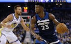 Minnesota Timberwolves' Jimmy Butler, right, drives the ball against Golden State Warriors' Stephen Curry (30) during the first half of an NBA basketb