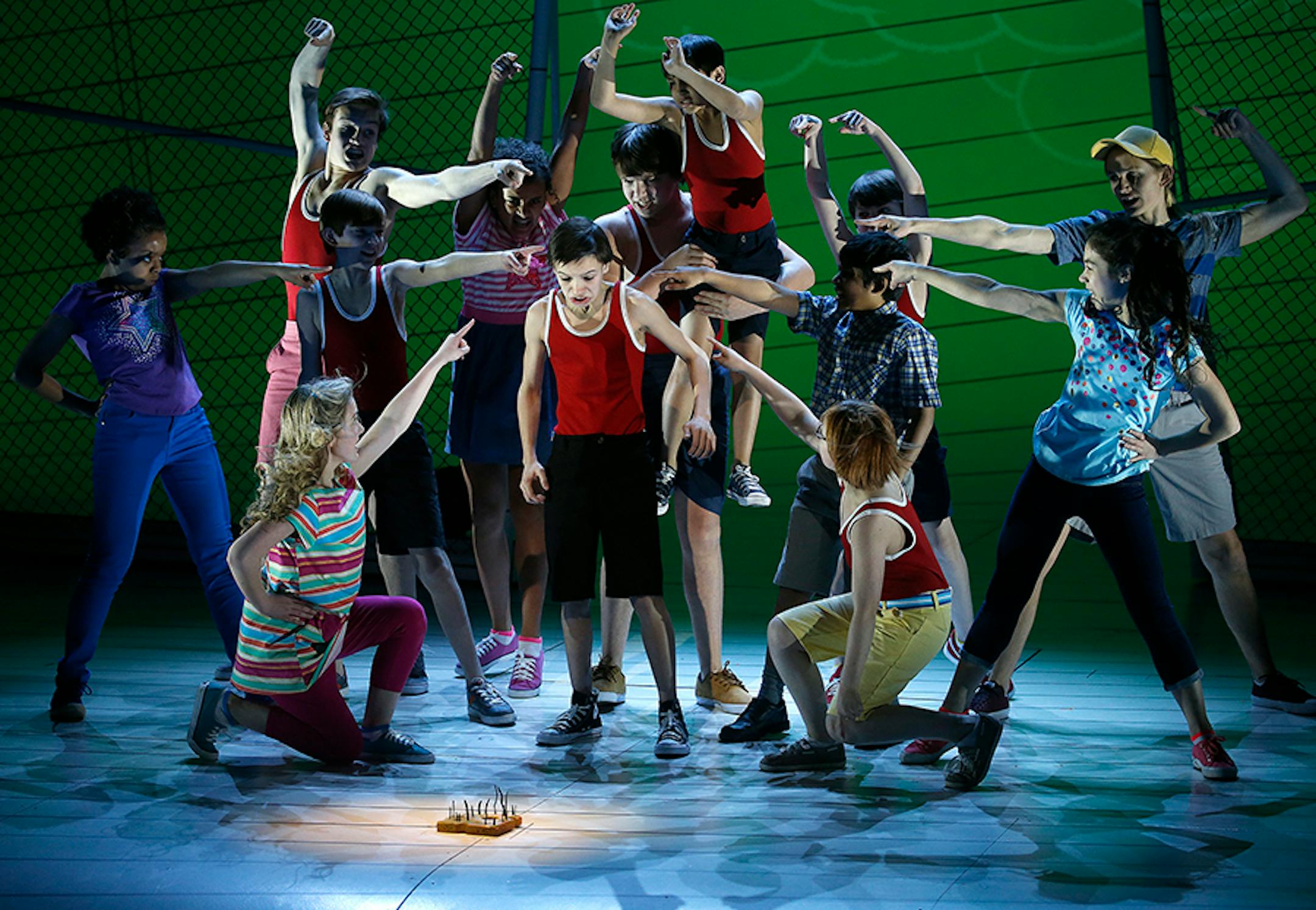 left, Greg, played by Ricky Falbo, with the cast during the playground scene with the moldy cheese found on the ground, Diary of a Wimpy Kid the Musical.