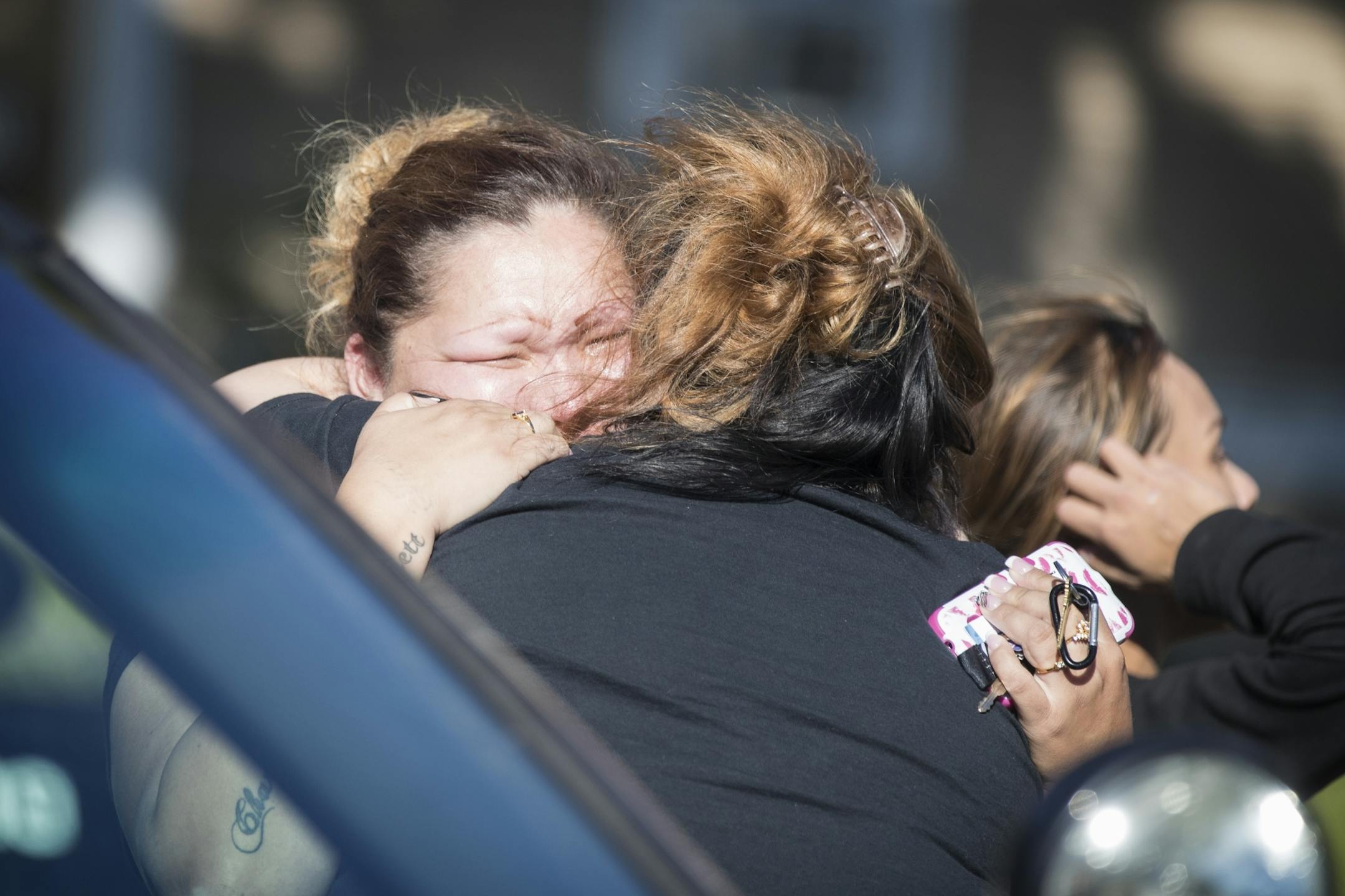 Family of the adult male victim grieve at the scene of the shooting. At far left is Julia Johnson, the sister of the adult victim.