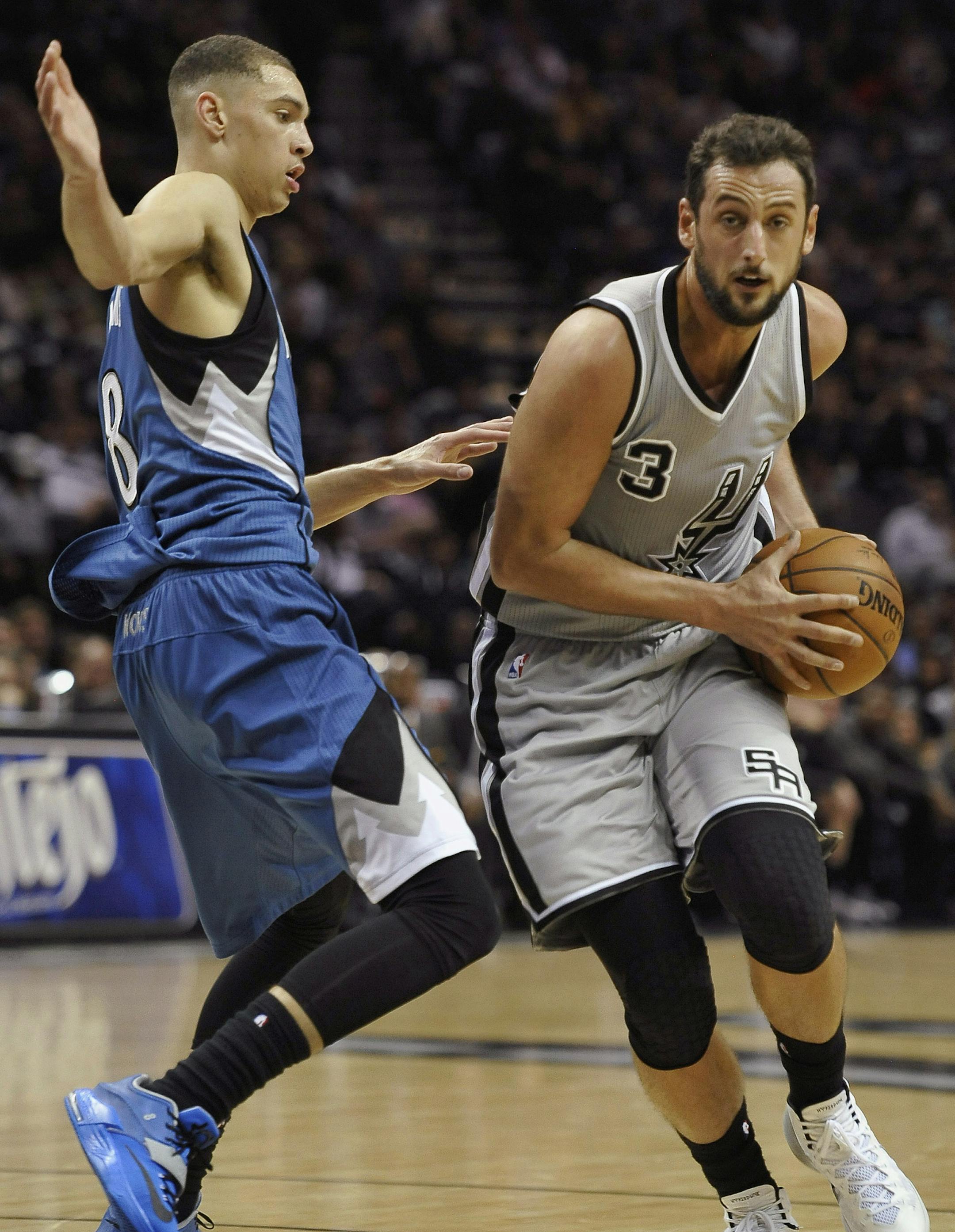 San Antonio Spurs guard Marco Belinelli, of Italy, drives around Minnesota Timberwolves guard Zach LaVine, left, during the first half of an NBA basketball game, Saturday, Dec. 6, 2014, in San Antonio. (AP Photo/Darren Abate)