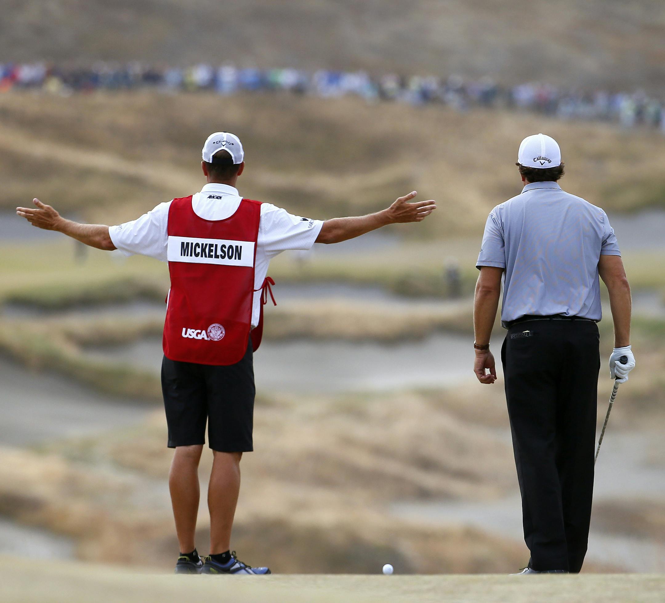 Phil Mickelson, right, and caddie Jim "Bones" Mackay look over the second hole during the first round of the U.S. Open golf tournament at Chambers Bay on Thursday, June 18, 2015 in University Place, Wash. (AP Photo/Matt York)