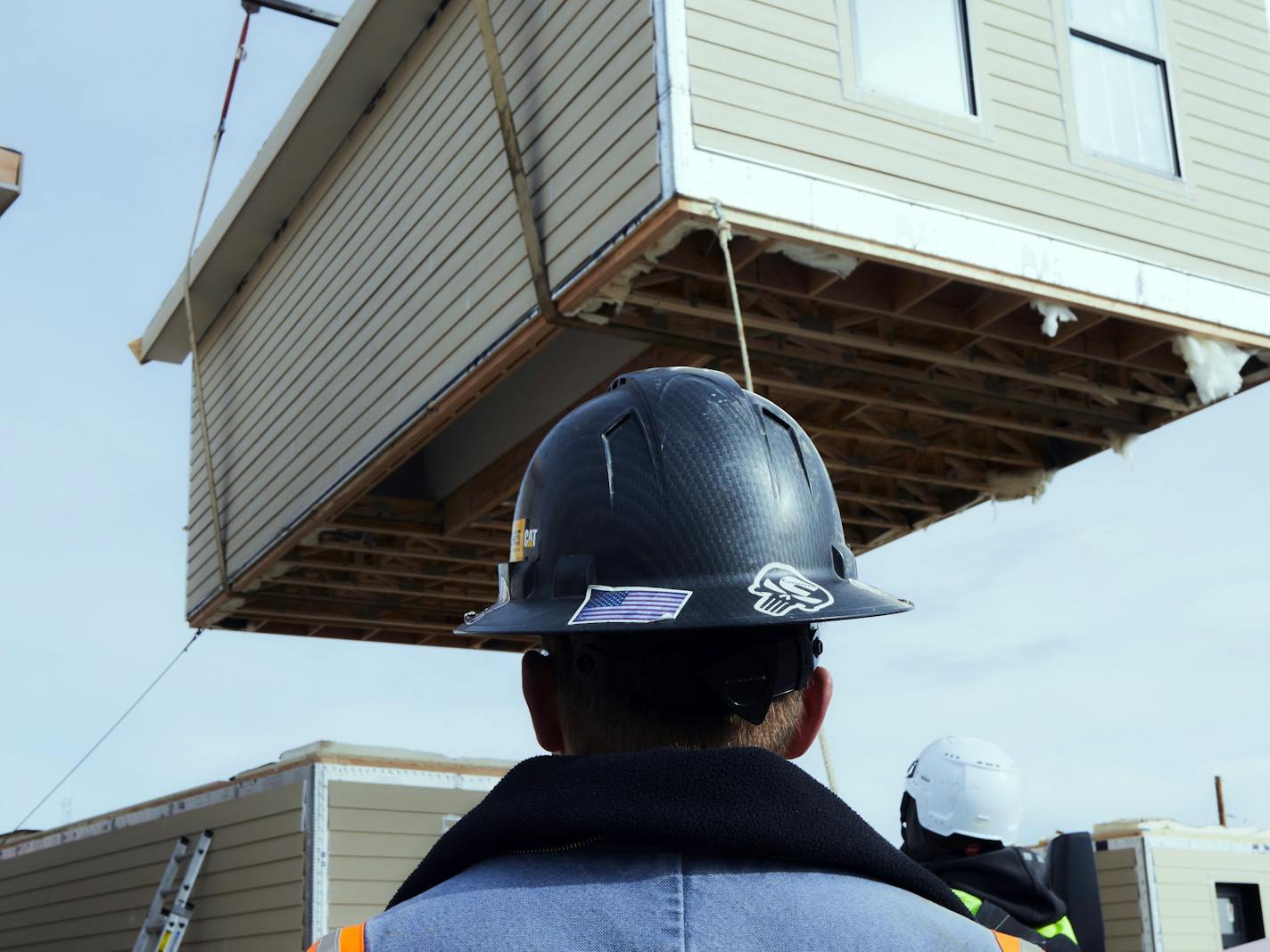 A crane swings a prefabricated housing unit into place at a development in Fairplay, Colo., on Dec. 12, 2023. The tantalizing potential of factory-built housing, also known as modular housing, continues to attract investors and entrepreneurs, including a start-up called Fading West that opened a factory in 2021 in the Colorado mountain town of Buena Vista. (Zeke Bogusky/The New York Times)