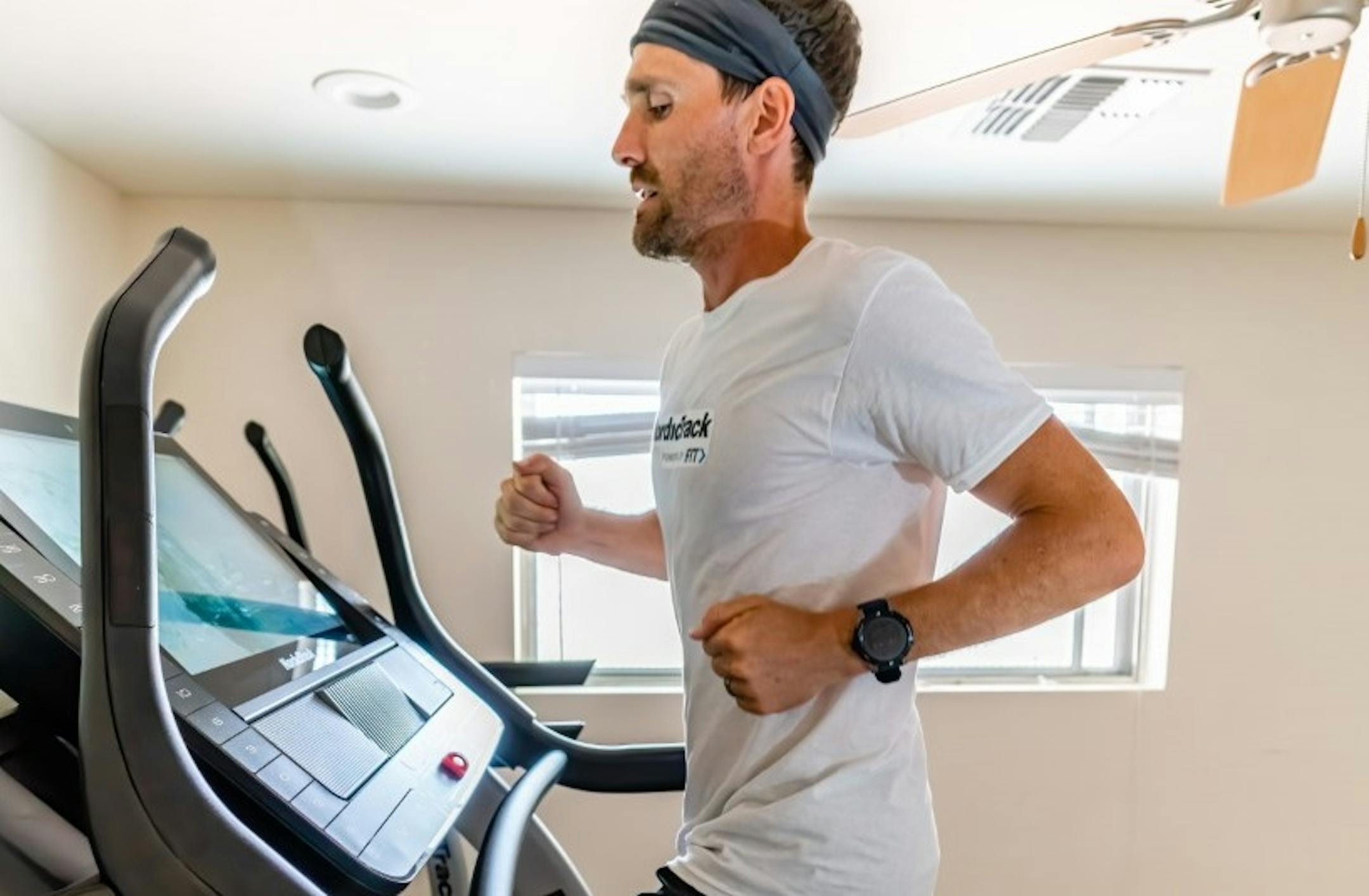 Zach Bitter in his basement on a NordicTrack X22i treadmill.