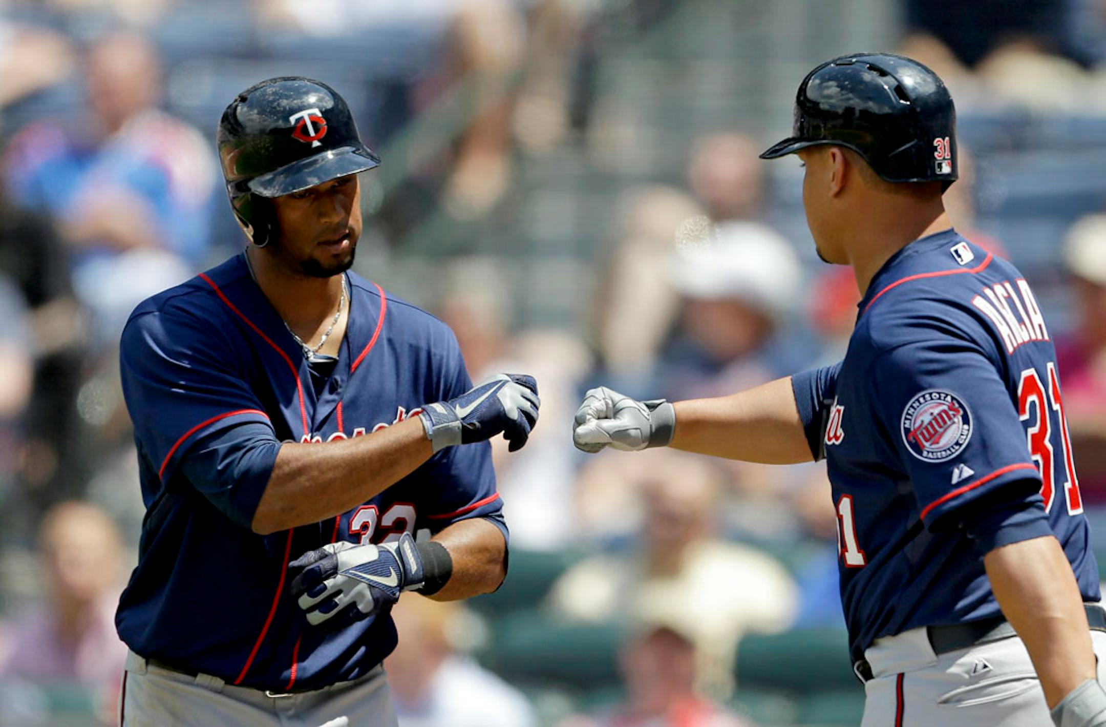 Minnesota Twins' Aaron Hicks, left, fist bumps teammate Oswaldo Arcia, right, after Hicks hit a home run in the ninth inning of a baseball game against the Atlanta Braves, Wednesday, May 22, 2013, in Atlanta.