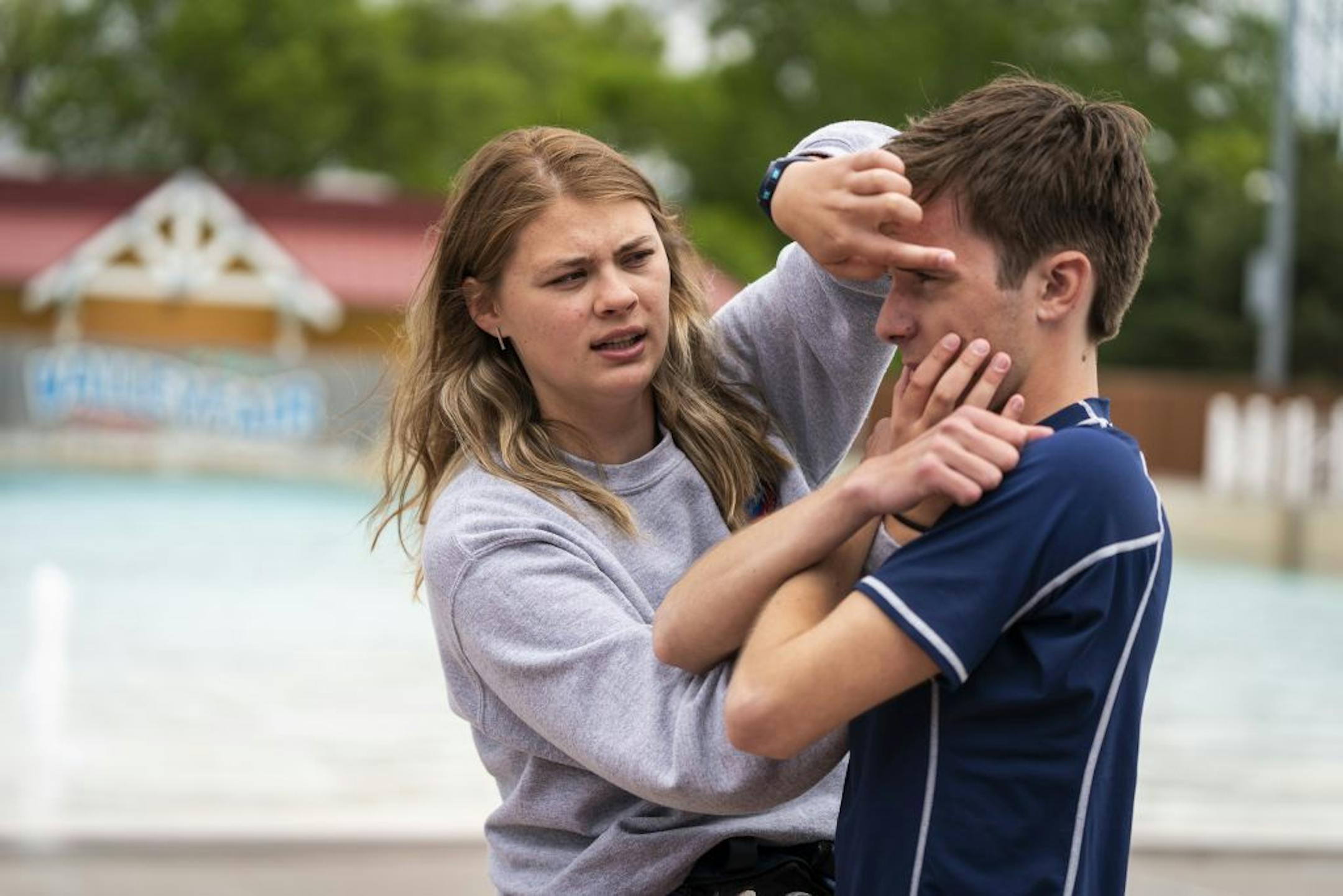 Aimee Ilkka, left, 19, of New Prague, leads an emergency response training session with Ben Williams, 19, of Prior Lake for lifeguards in the water park area called Breakers Bay at ValleyFair.