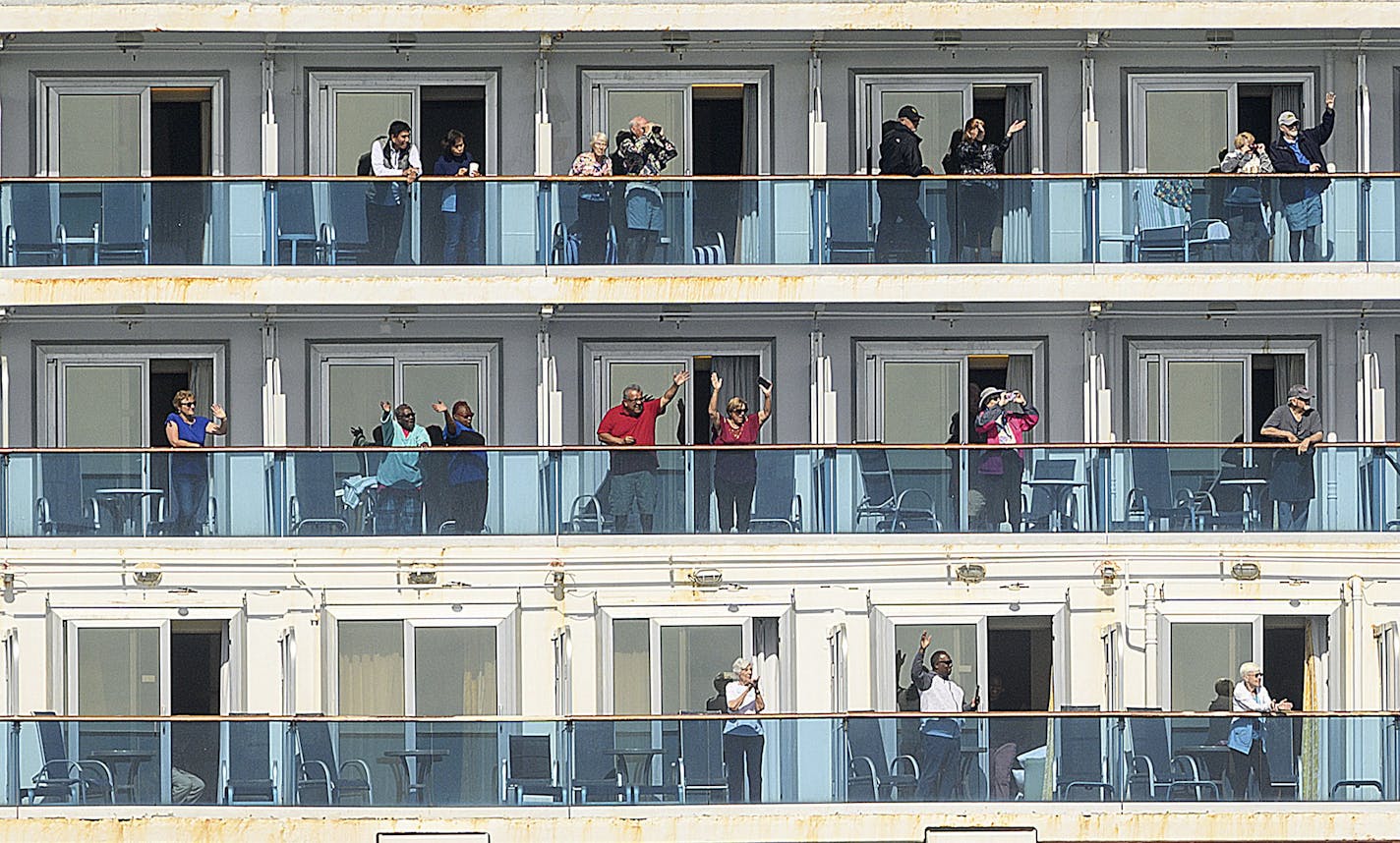 Passenger aboard the Grand Princess celebrate as they arrive in Oakland, Calif., on Monday, March 9, 2020. The cruise ship, which had maintained a holding pattern off the coast for days, is carrying multiple people who tested positive for COVID-19, a disease caused by the new coronavirus. (AP Photo/Noah Berger)