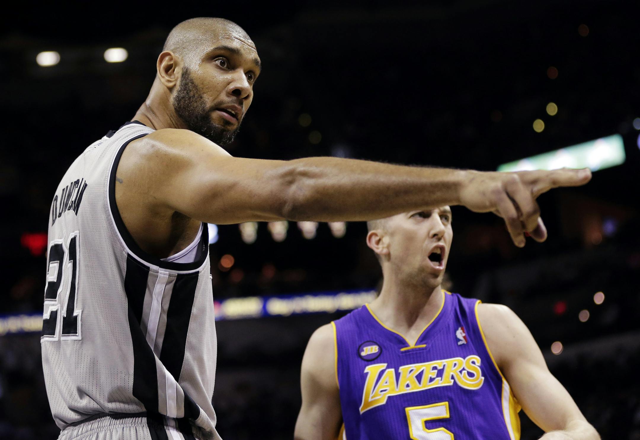 San Antonio Spurs' Tim Duncan (21) and Los Angeles Lakers' Steve Blake (5) argue a call during the first half of Game 1 of their first-round NBA playoff basketball series, Sunday, April 21, 2013, in San Antonio. (AP Photo/Eric Gay)