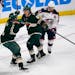 Minnesota Wild left wing Kirill Kaprizov, middle, celebrates with defenseman Calen Addison, left, after scoring the game-winning goal to defeat the Co