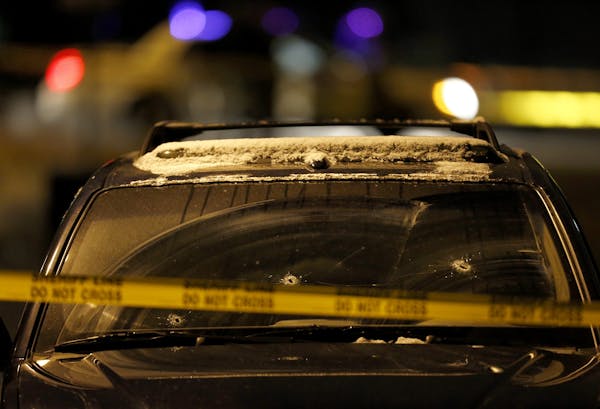 A parked SUV with bullet holes in the windshield sat surrounded by crime-scene tape on 7th Street N. in Oakdale on Monday night.