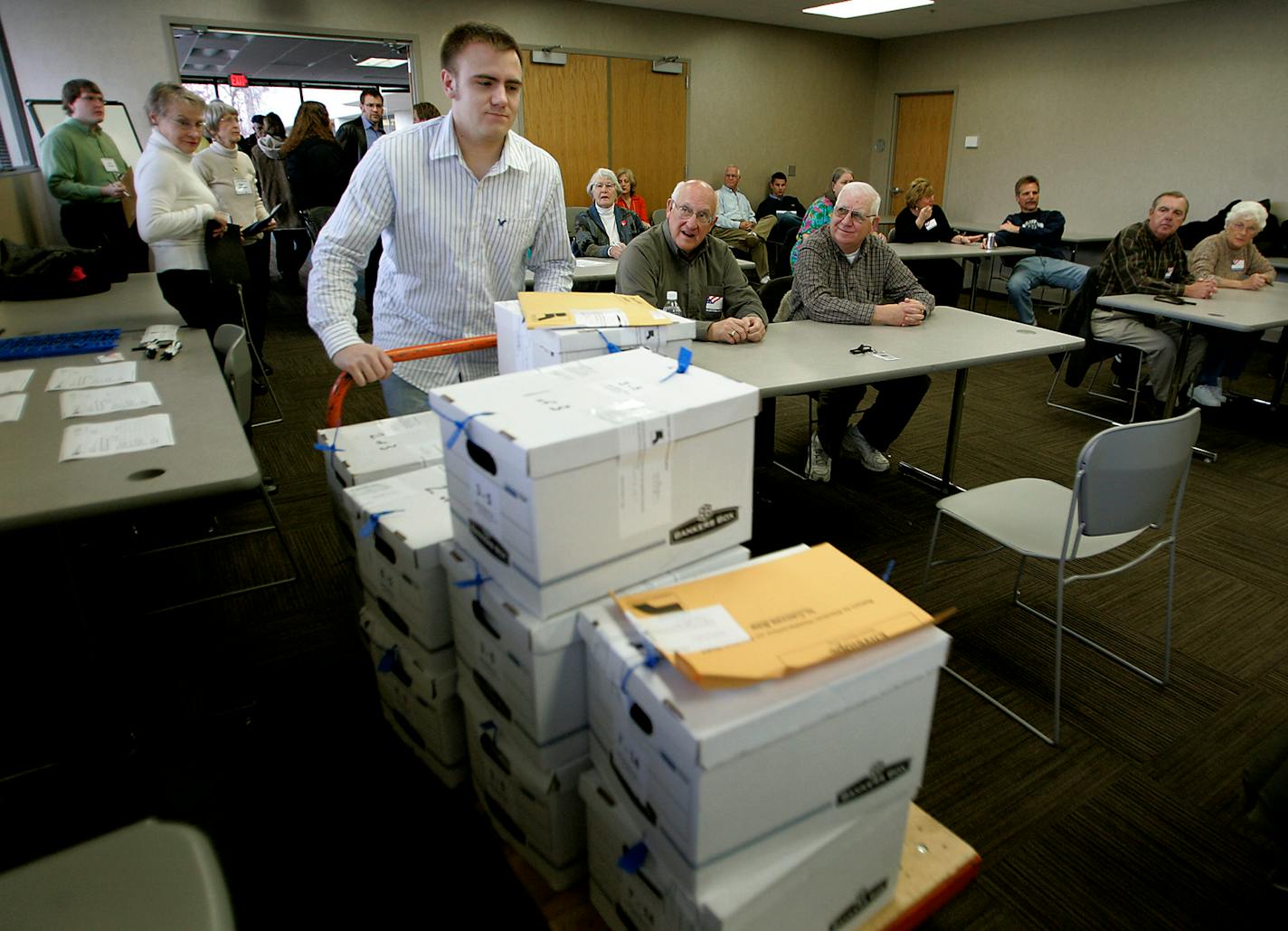 Luke Leadbetter, who works at the Elections Bureau, moved sealed boxes containing the ballots into a conference room Monday. Hand-counting several precincts helps officials determine how accurate the scanning machines were in the count.