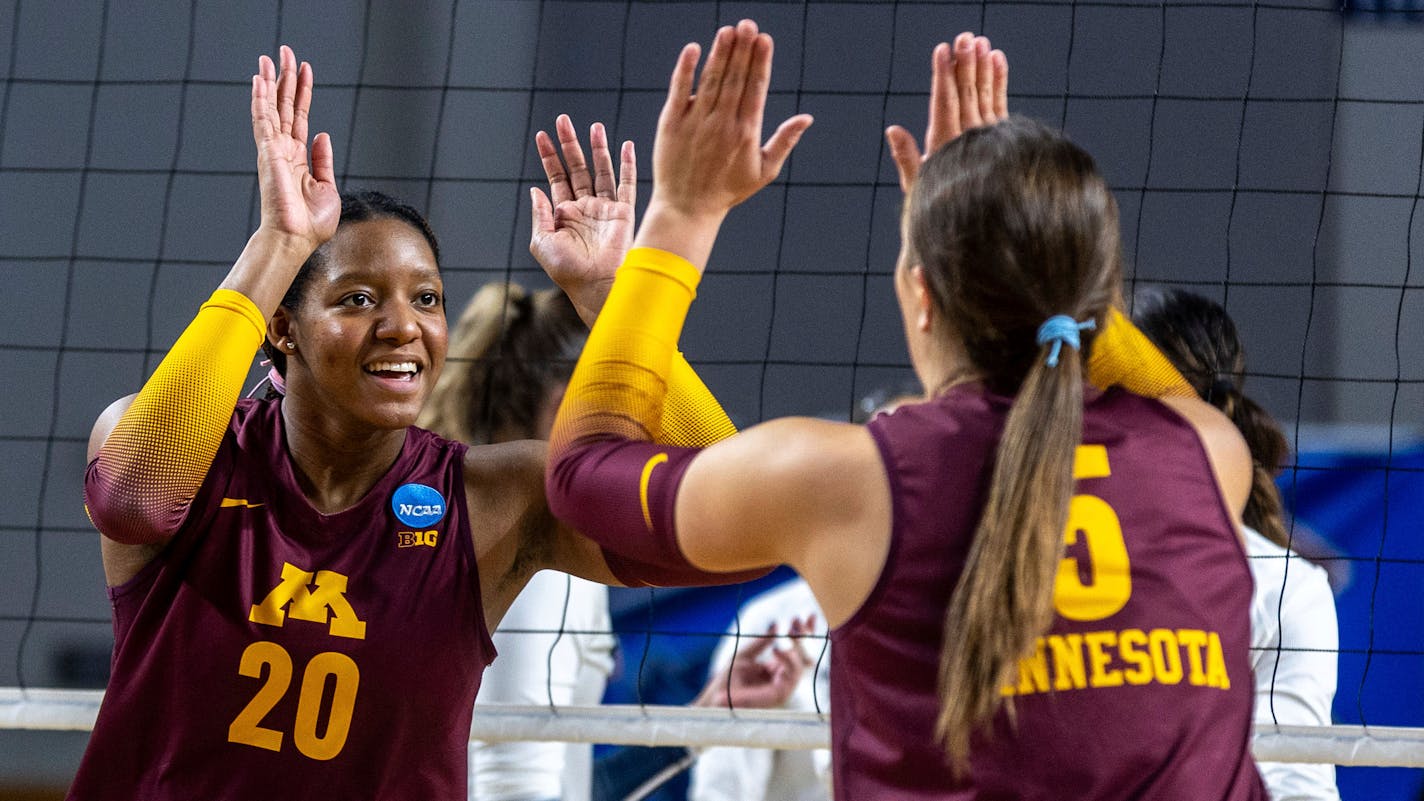 Minnesota's Arica Davis (20) celebrates a point against Utah State with Melani Shaffmaster.