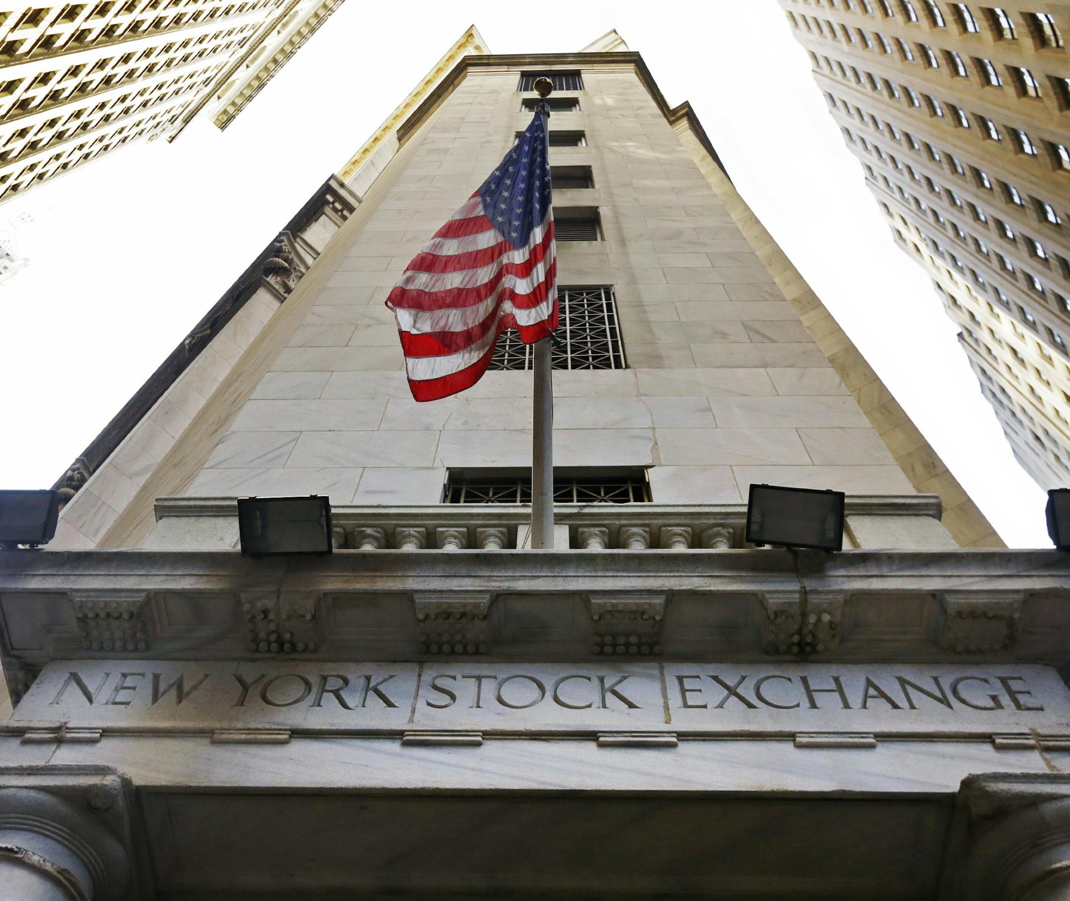 FILE - In this Friday, Nov. 13, 2015, file photo, the American flag flies above the Wall Street entrance to the New York Stock Exchange. Global stock markets traded in fairly narrow ranges Tuesday, Sept. 19, 2017, as investors paused for breath, a day after U.S. stock markets struck a record high and geared up for the latest interest rate decision from the U.S. Federal Reserve. (AP Photo/Richard Drew, File)
