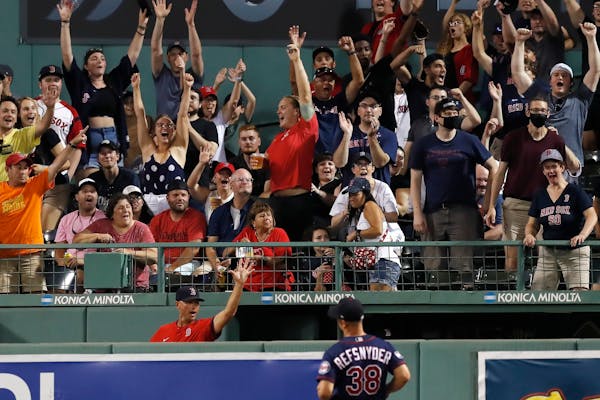 Fans reacts to the two-run home run by Boston Red Sox's Rafael Devers in front of Minnesota Twins' Rob Refsnyder (38) during the sixth inning of a bas