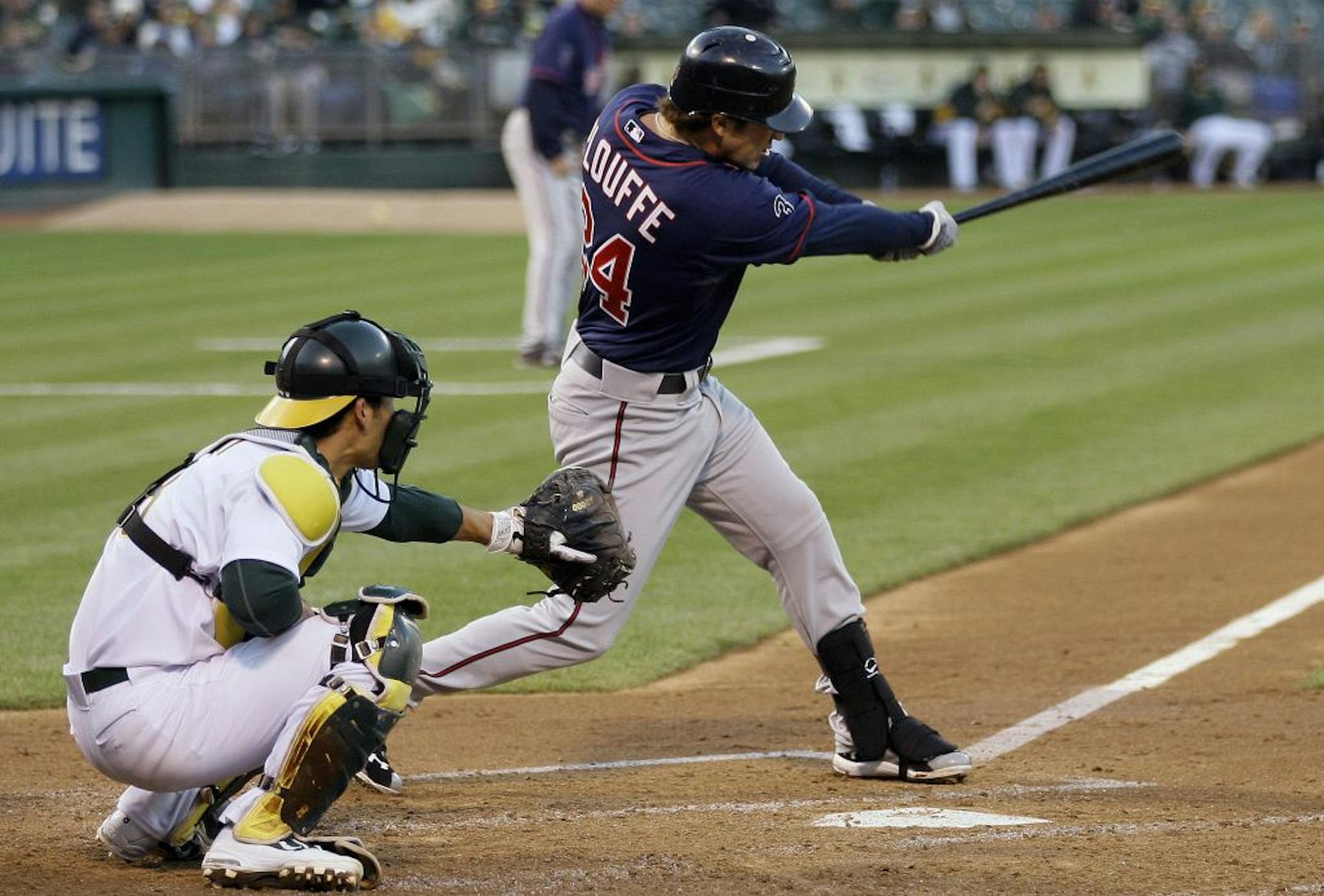 Minnesota's Trevor Plouffe hits a two-run single off Oakland's Brandon McCarthy in the third inning. Athletics catcher is Kurt Suzuki.