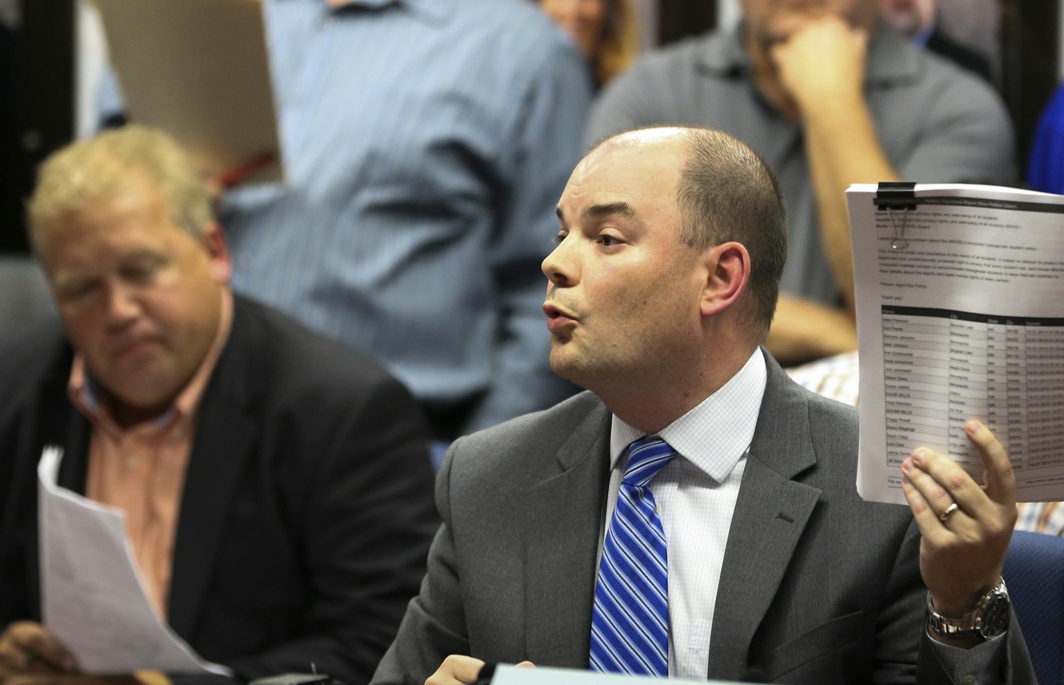 Jason Adkins held up a petition with 3,300 signatures against the transgender policy during the Minnesota State High School Leagues public hearing on their proposed transgender policy on Wednesday, October 1, 2014 in Brooklyn Center.