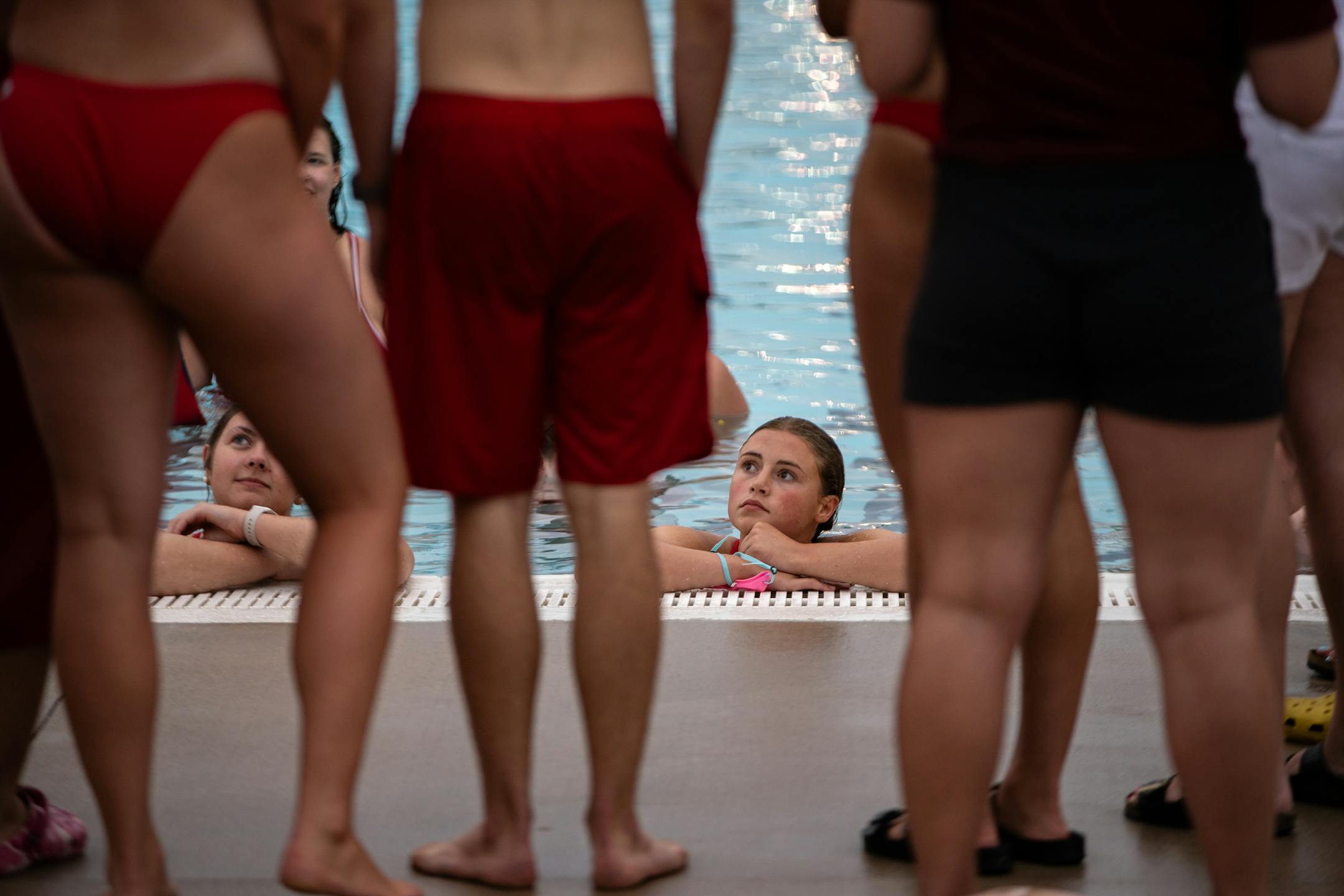 Lifeguards in training discuss the previous practice drill during lifeguard lessons.