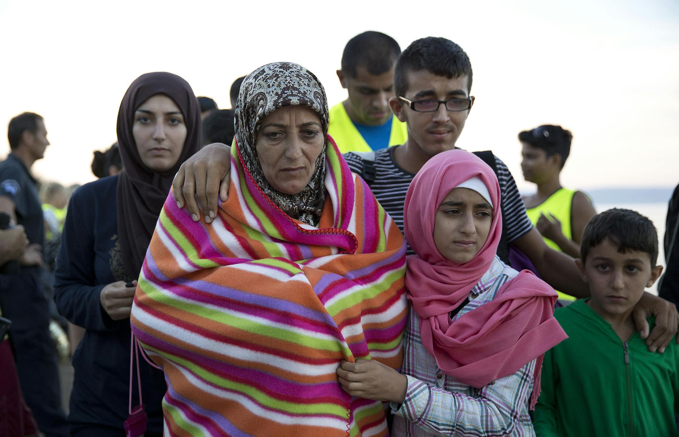 A Syrian family walk after they arrived with other refugees from Turkey to the shores of the Greek island of Lesbos, on a inflatable dinghy, Friday, Sept. 25, 2015. More than 260,000 asylum-seekers have arrived in Greece so far this year, most reaching the country's eastern islands on flimsy rafts or boats from the nearby Turkish coast.(AP Photo/Petros Giannakouris) ORG XMIT: MIN2015092513172757