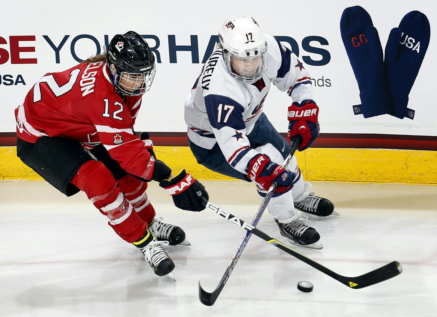 Meaghan Mikkelson (12) of team Canada and Jocelyne Lamoureux (17) of team USA fought for the puck in the first period. ] CARLOS GONZALEZ cgonzalez@startribune.com - December 28, 2013, St. Paul, Minn., Xcel Energy Center, Women's Hockey, USA vs. Canada