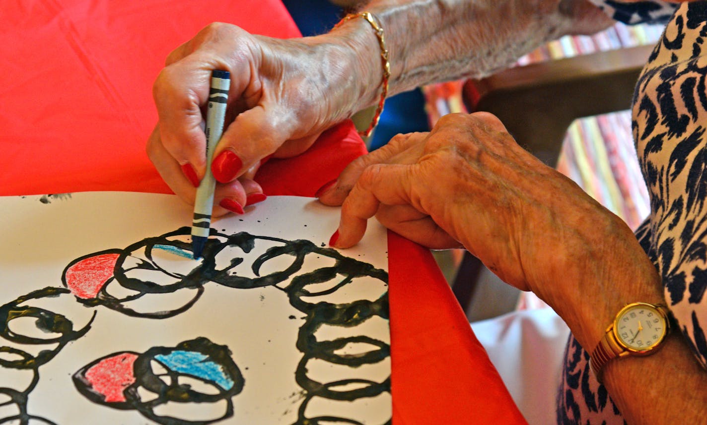 The art project was created with a toilet paper roll tube and black ink to create the circles which were colored in with crayons. ]Art Across the Ages is an Intergenerational art class with seniors and kids working together at the The Commons on Marice in Eagan. It's a bonding experience for young and old which helps children learn about the aging process. Richard.Sennott@startribune.com Richard Sennott/Star Tribune Eagan Minn. Thursday 6/12/2014) ** (cq)