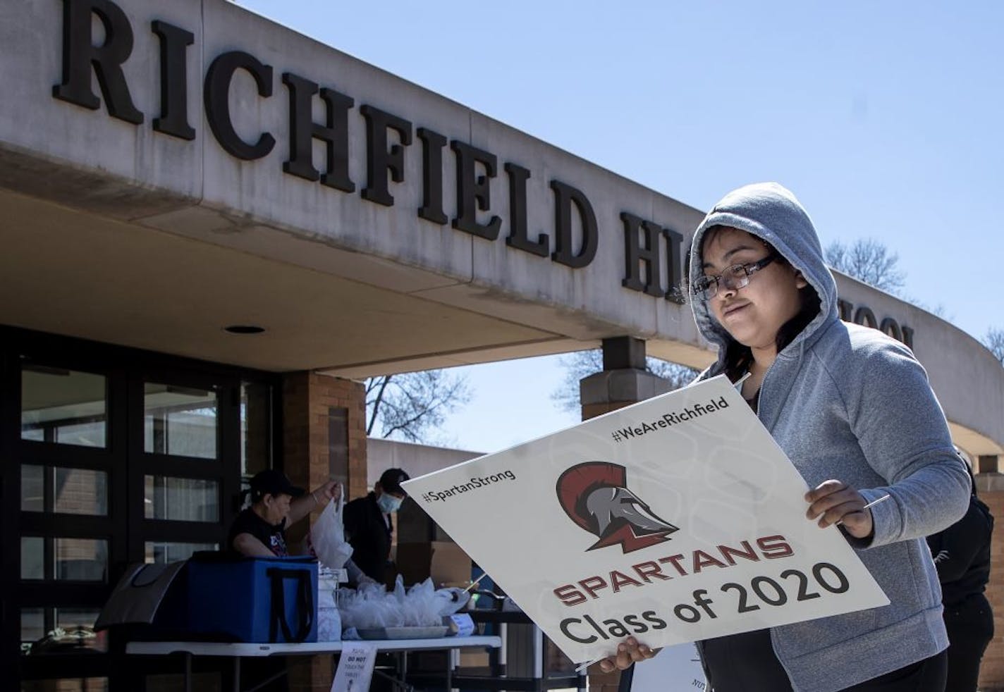 Richfield High School senior Evelin Estrada looked over the class of 2020 yard sign after picking it up at the school on Thursday.