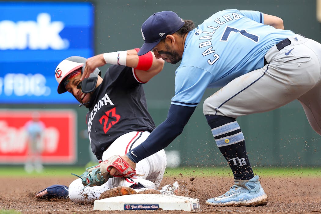 Rays third baseman José Caballero tags out Royce Lewis of the Twins at third in the 10th inning Thursday at Target Field.