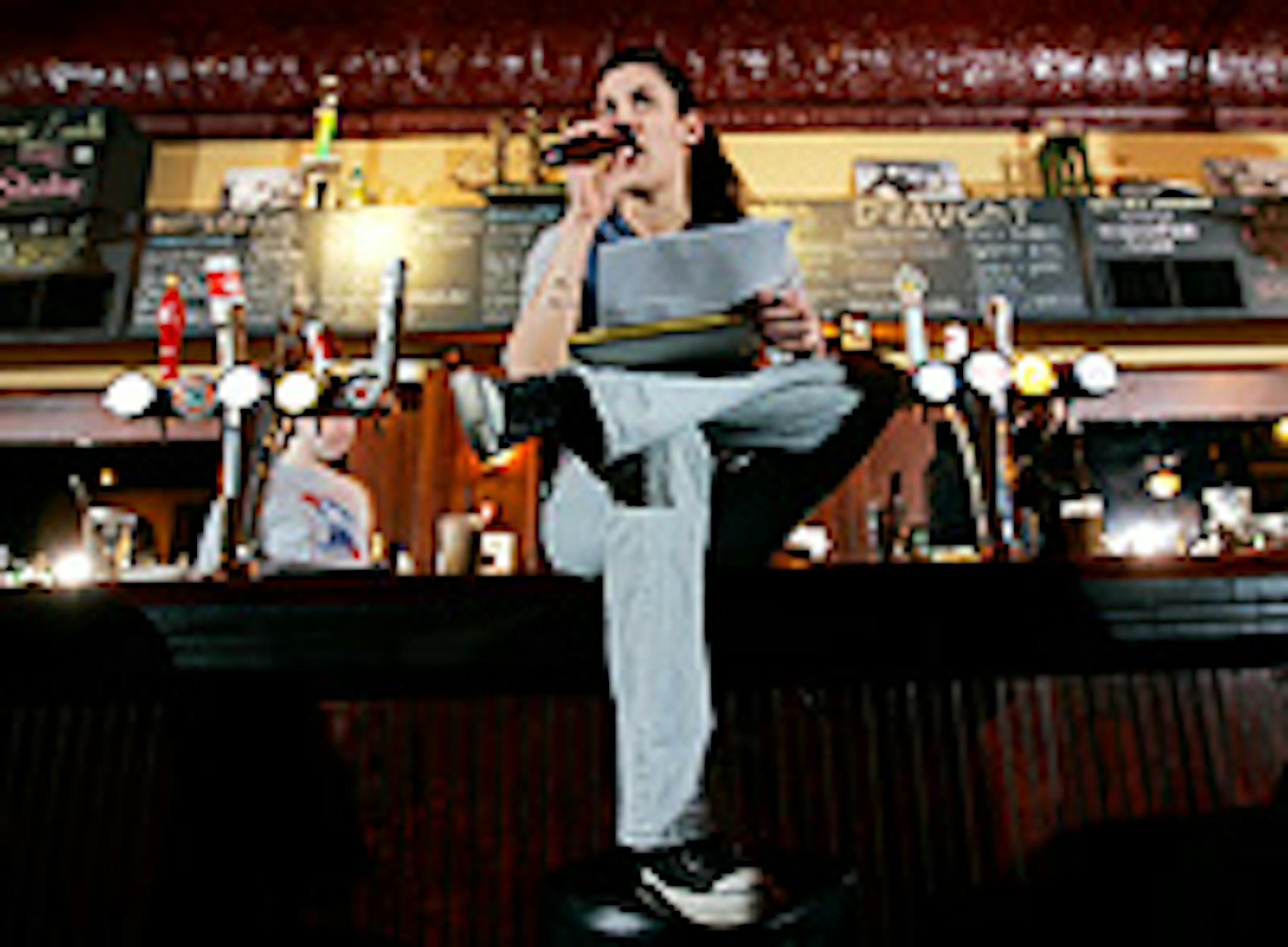 Rapper Dessa asking questions from the bar during Trivia night at Nomad World Pub on Monday.