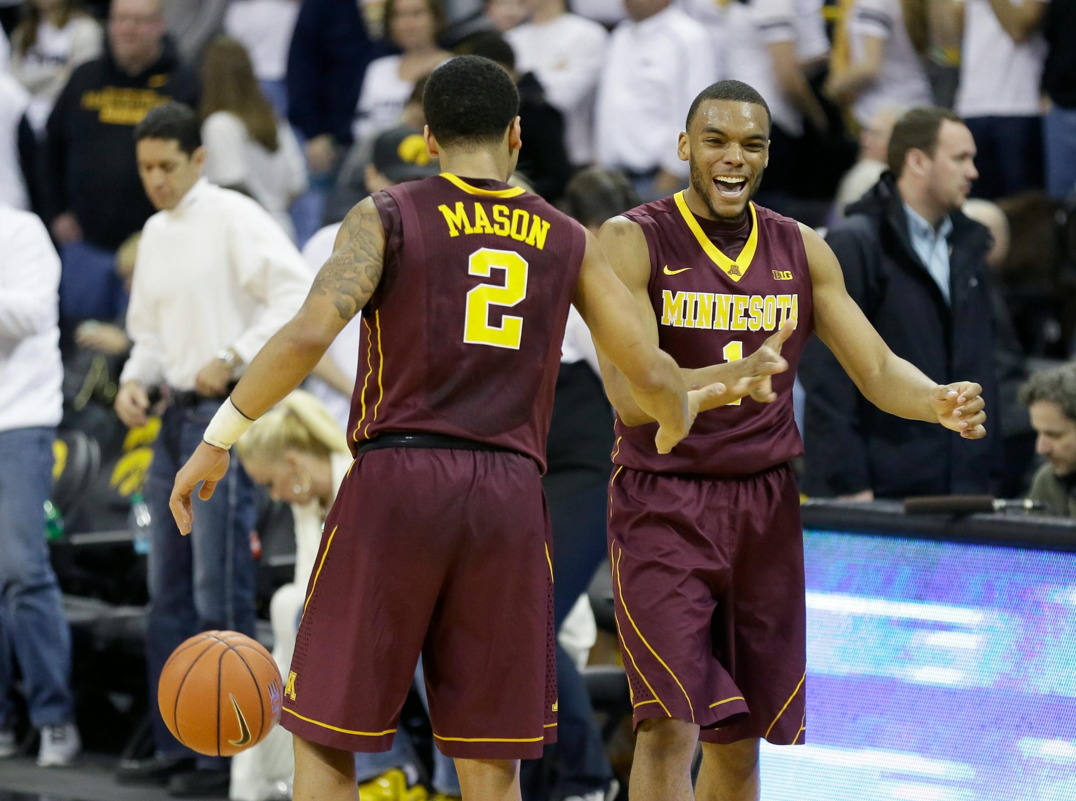 Minnesota guard Andre Hollins, right, celebrates with teammate Nate Mason after an NCAA college basketball game against Iowa, Thursday, Feb. 12, 2015, in Iowa City, Iowa. Minnesota won 64-59. (AP Photo/Charlie Neibergall)