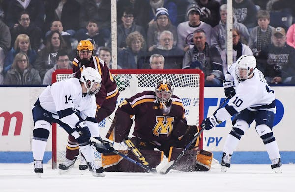 Gophers goaltender Eric Schierhorn stops a shot by Penn State's Brandon Biro (10) as Penn State's Nate Sucese waits for a rebound.