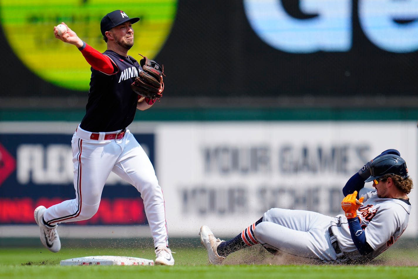 Twins second baseman Kyle Farmer throws to first for a double play after getting out Detroit's Zach McKinstry during the ninth inning