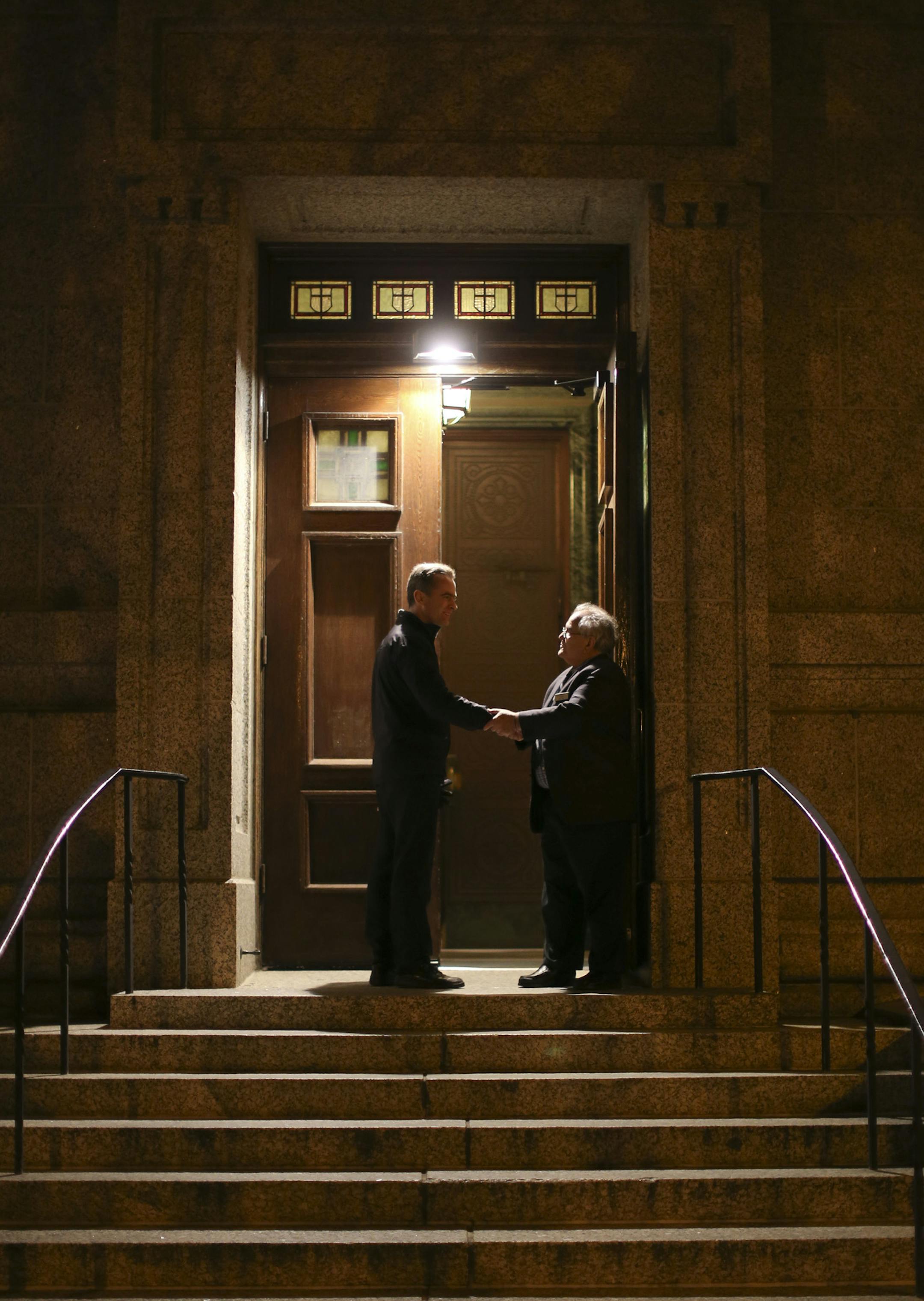 An usher, right, who declined to give his name, greeted a man arriving for a Penitential Holy Hour prayer service Sunday night at the Cathedral of St. Paul.
