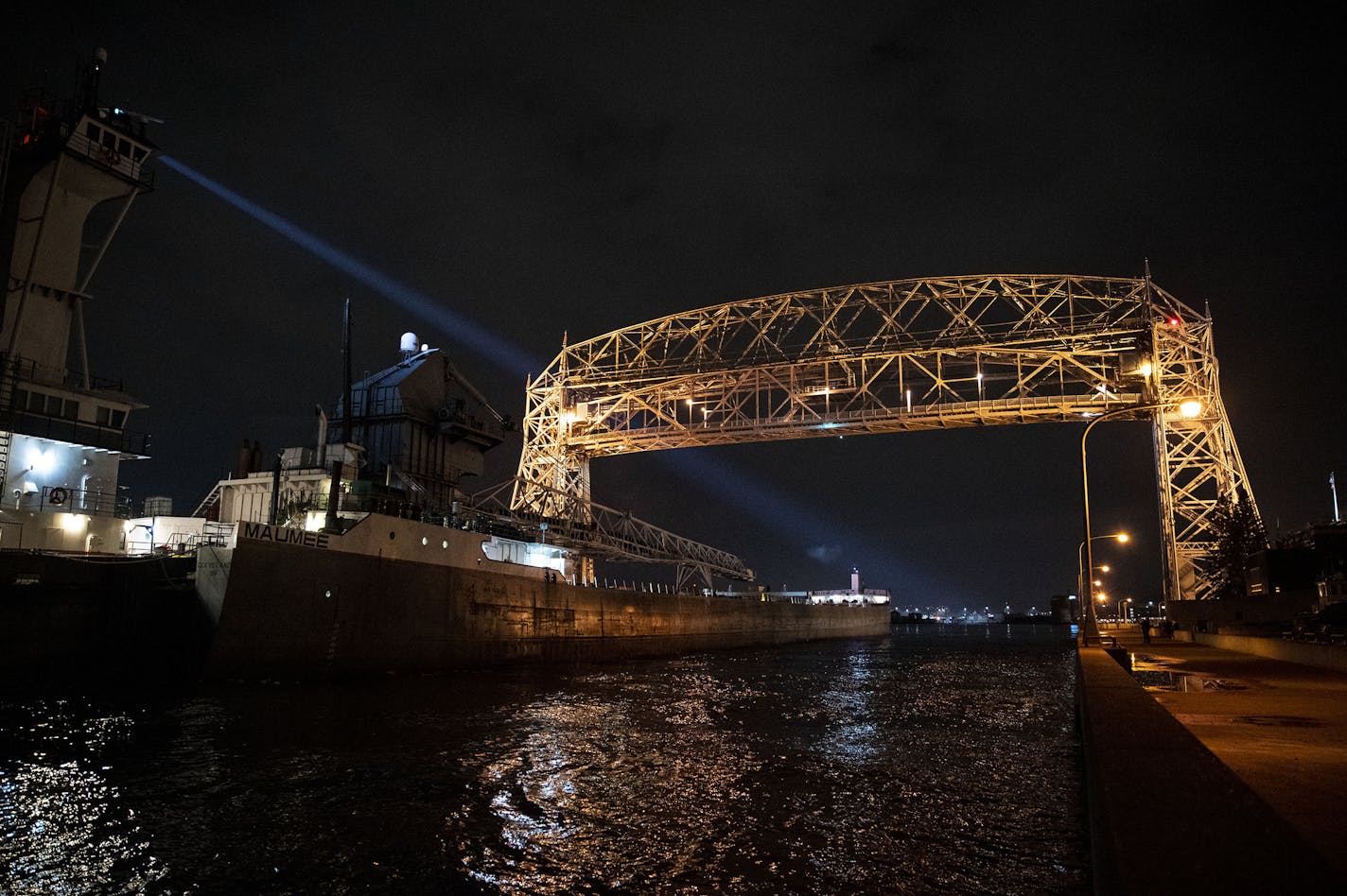 The Victory illuminated it's spotlight as it pulled into the Duluth Harbor under the aerial lift bridge on Tuesday night. ] ALEX KORMANN • alex.kormann@startribune.com The Duluth shipping season got underway this week with the first ship of the season coming into the Duluth harbor on Tuesday night. The Victory moved under the aerial lift bridge around 9:40PM on Tuesday March 24, 2020.