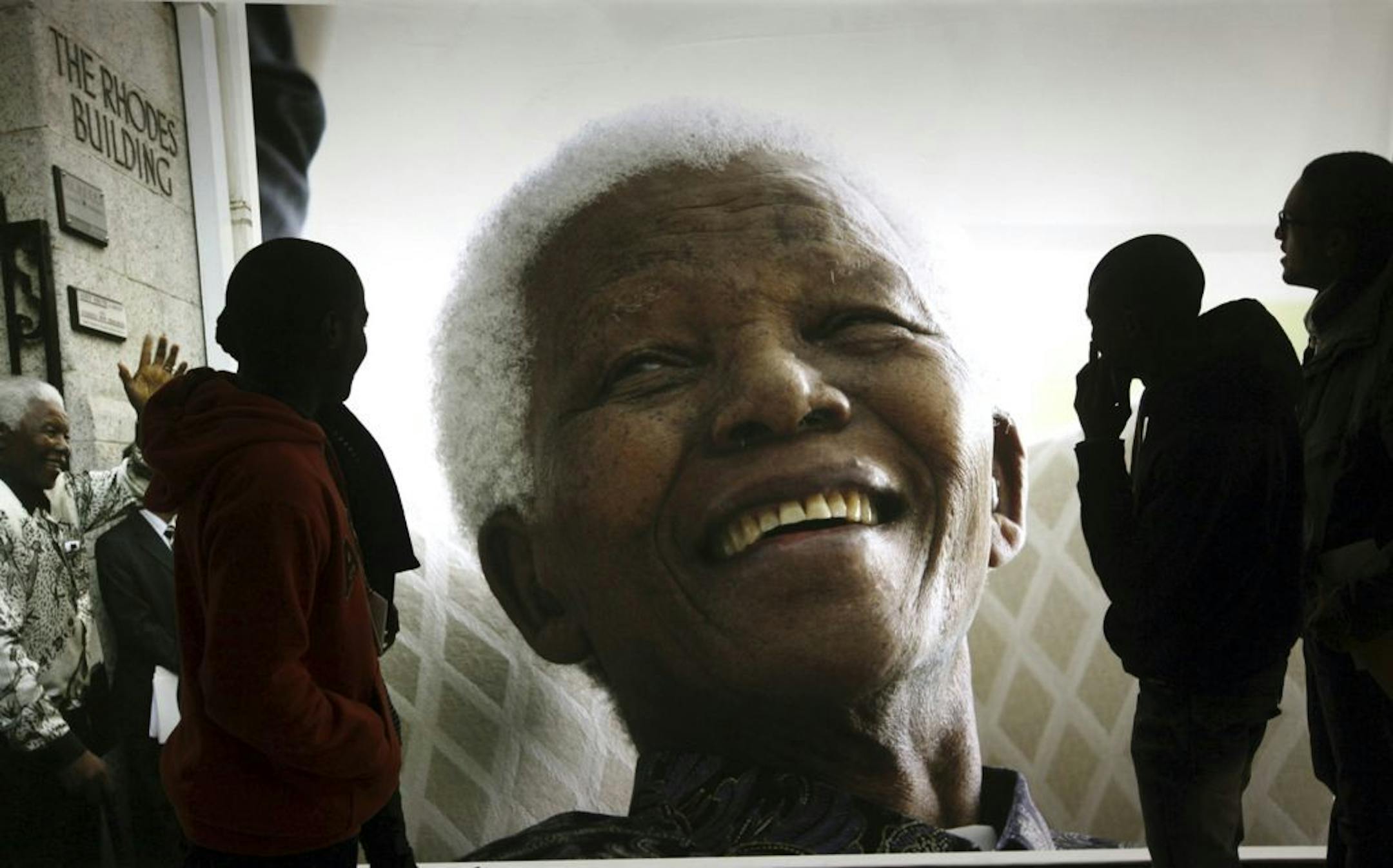 In this June 27, 2013 file photo, photographs of former South African President Nelson Mandela are displayed at the Nelson Mandela Legacy Exhibition at the Civic Centre in Cape Town, South Africa.