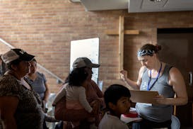 Annie director people, mostly Ecuadorians, on how to get food from the food shelf that she runs in Minneapolis, Minn., on Saturday, June 10, 2023.   ]
