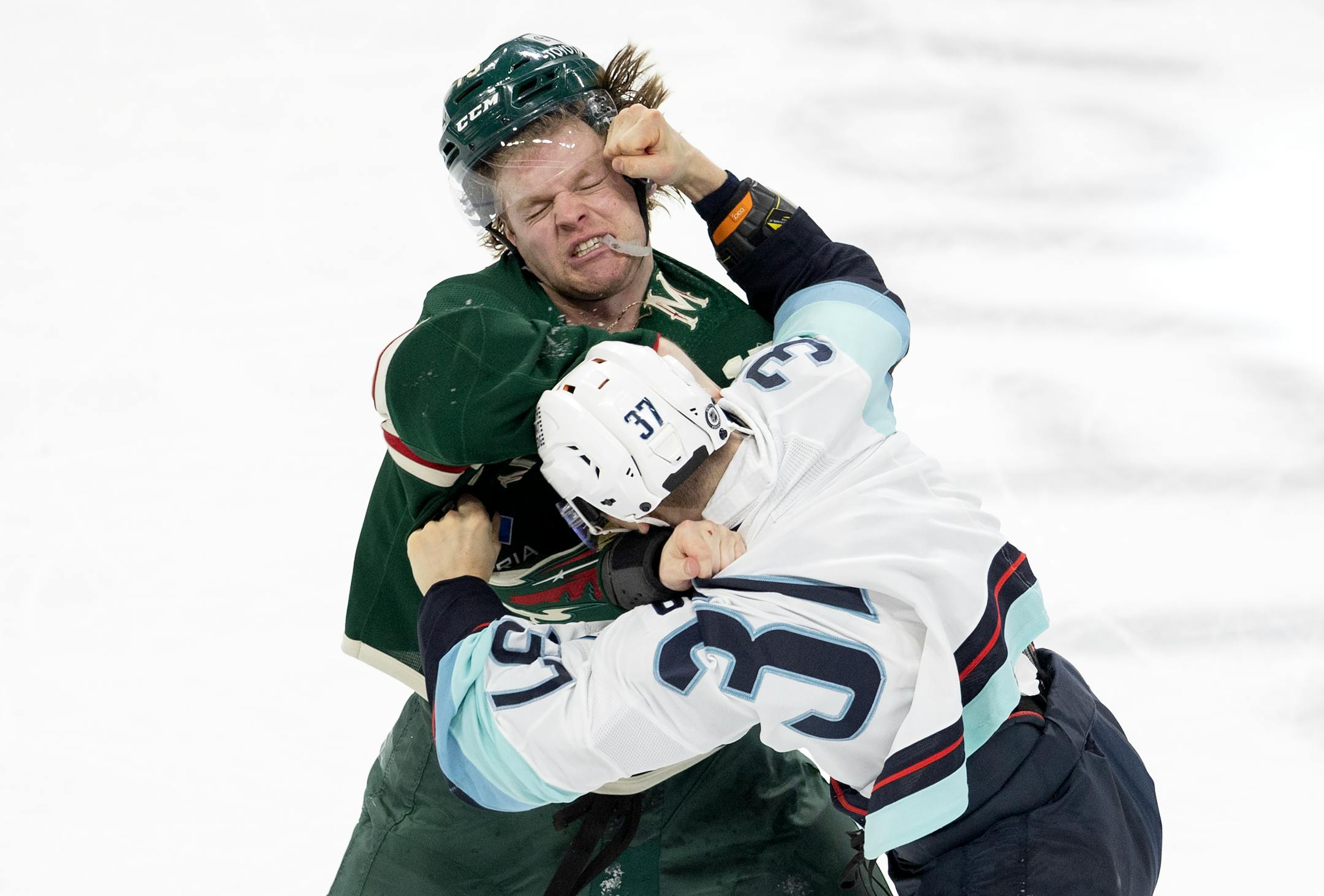 Yanni Gourde (37) of the Seattle Kraken and Mason Shaw (15) of the Minnesota Wild fight in the third period.