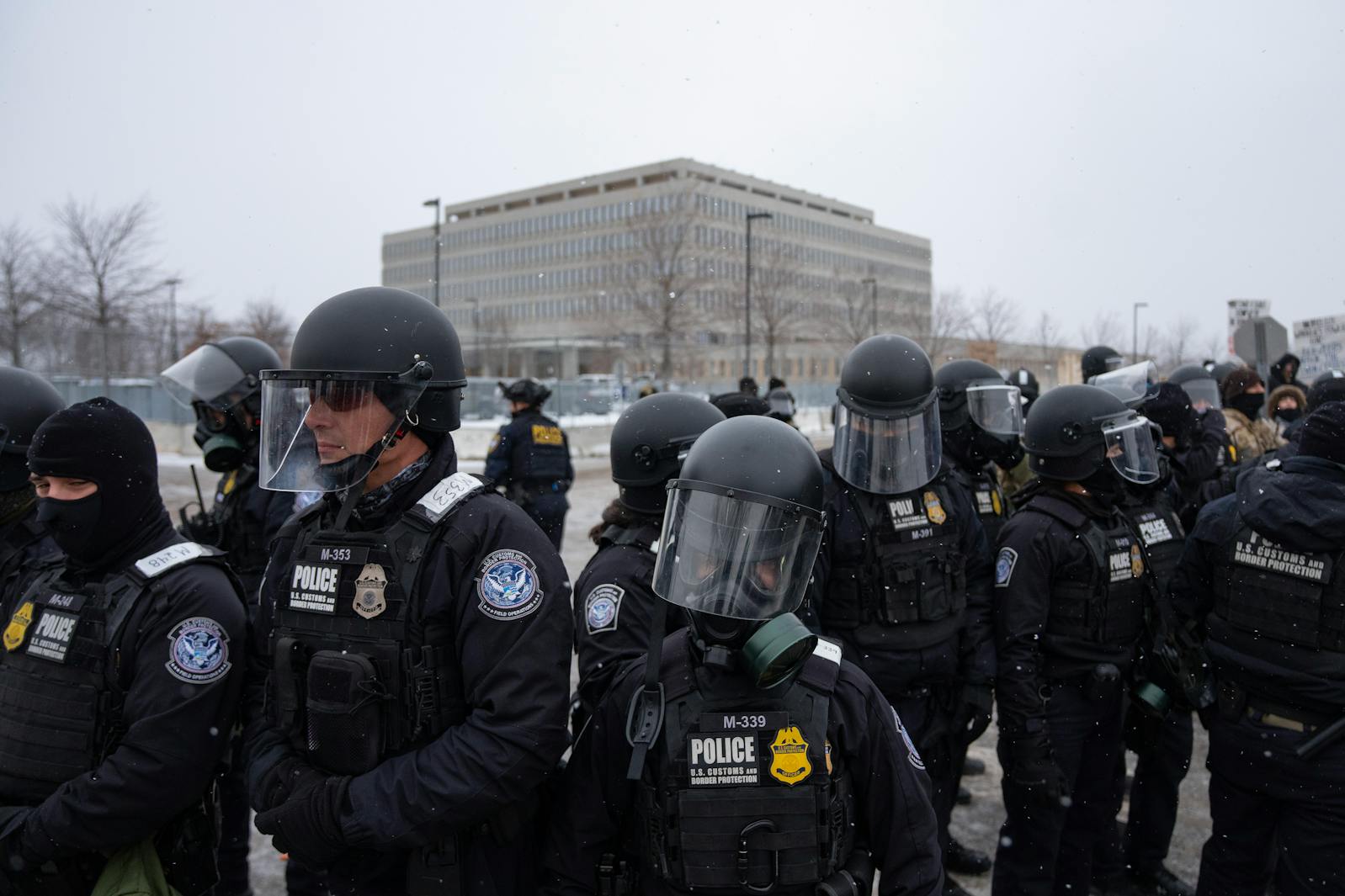 U.S. Customs and Border Protection agents confront peaceful protesters that have encroached onto the road outside the Whipple Federal Building in Minneapolis on Friday, Jan. 16.
