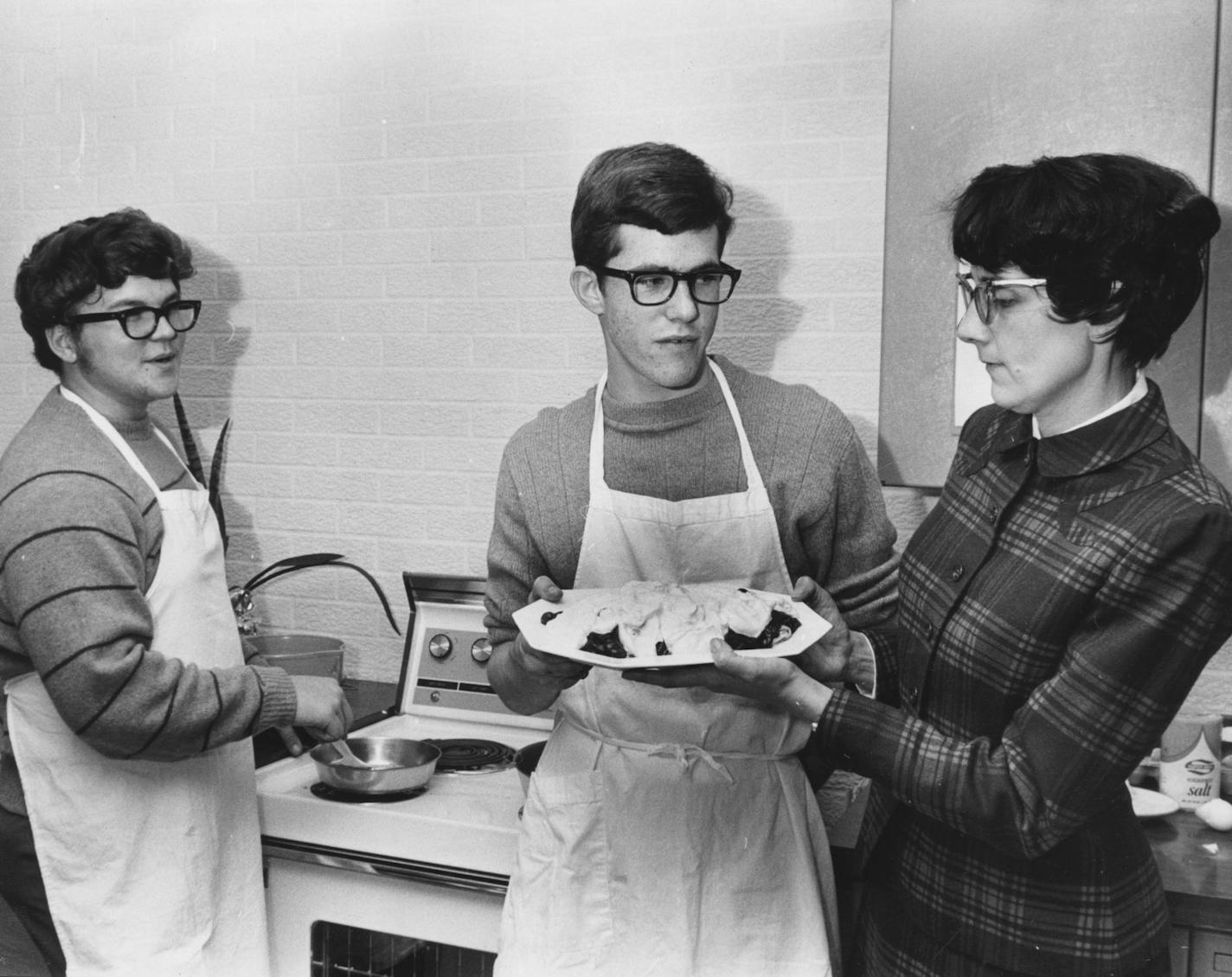 1969-Boys cooking class at Kennedy High School. Mrs. Shroyer checks crepes made by Wesley Lund and Tom Stone. For Taste 40