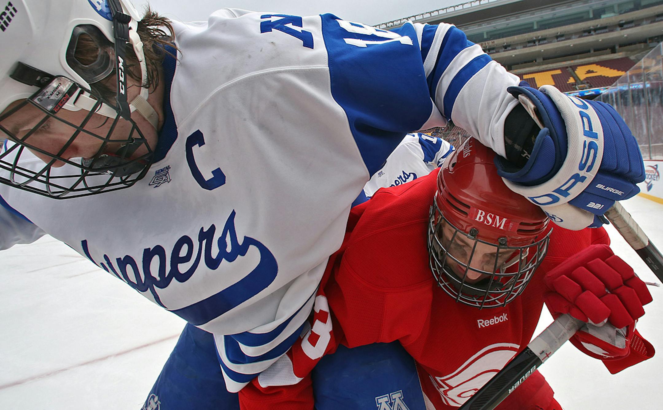 Outdoor games at TCF Bank Stadium on Saturday -- as shown by Benilde-St. Margaret's Auggie Moore (right) battling Minnetonka's AJ Klein for the puck -- were a captivating warmup for the state's annual puck showcase, Hockey Day Minnesota.