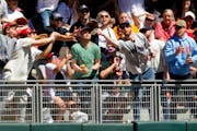 Fans reach for the home run ball hit by Minnesota Twins' Ryan Jeffers against the Boston Red Sox in the third inning of a baseball game Sunday, May 5,