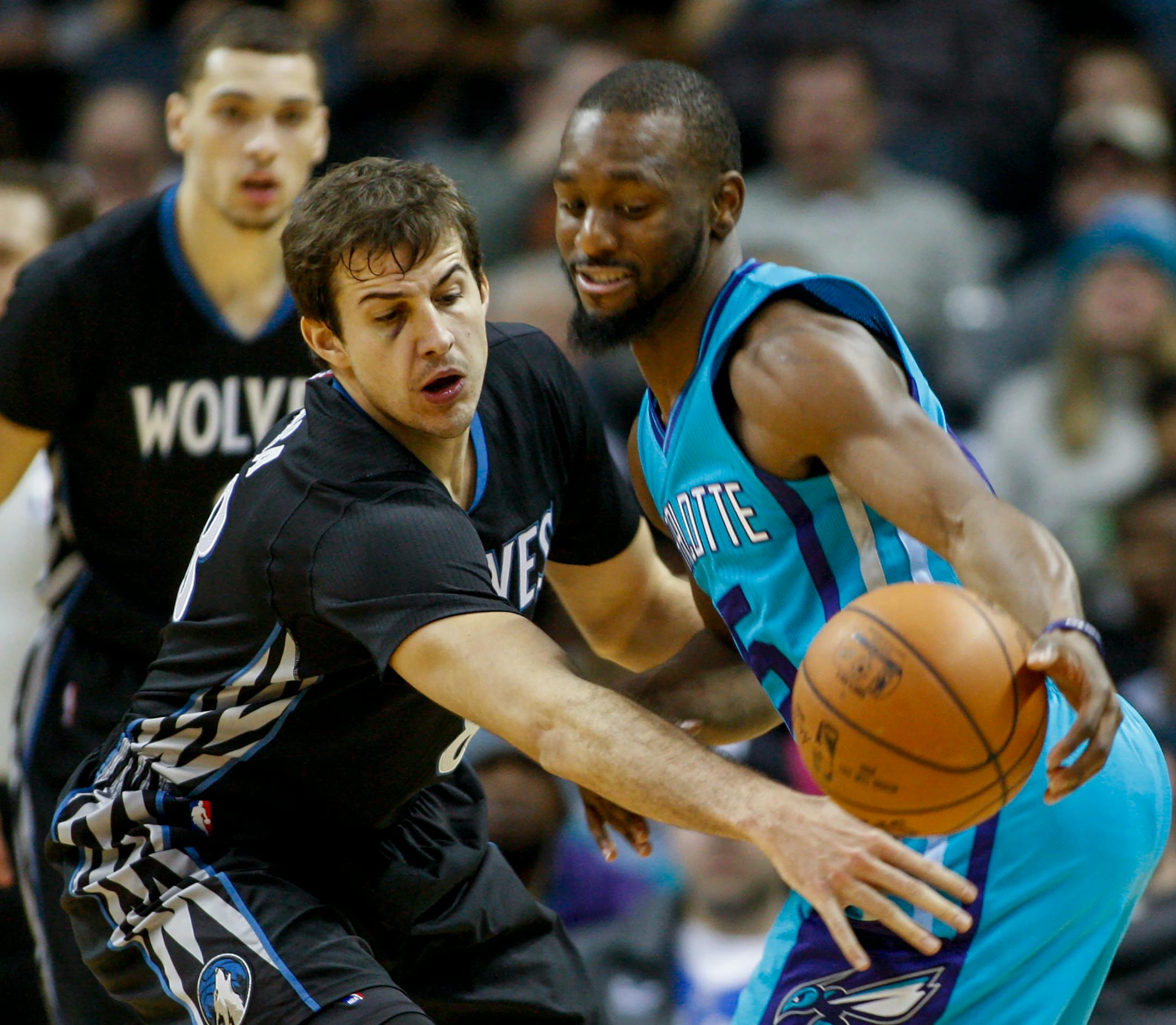 Minnesota Timberwolves forward Nemanja Bjelica, left, of Serbia, knocks away the basketball from Charlotte Hornets guard Kemba Walker in the second half of an NBA basketball game in Charlotte, N.C., Saturday, Dec. 3, 2016. Minnesota won 125-120. (AP Photo/Nell Redmond)