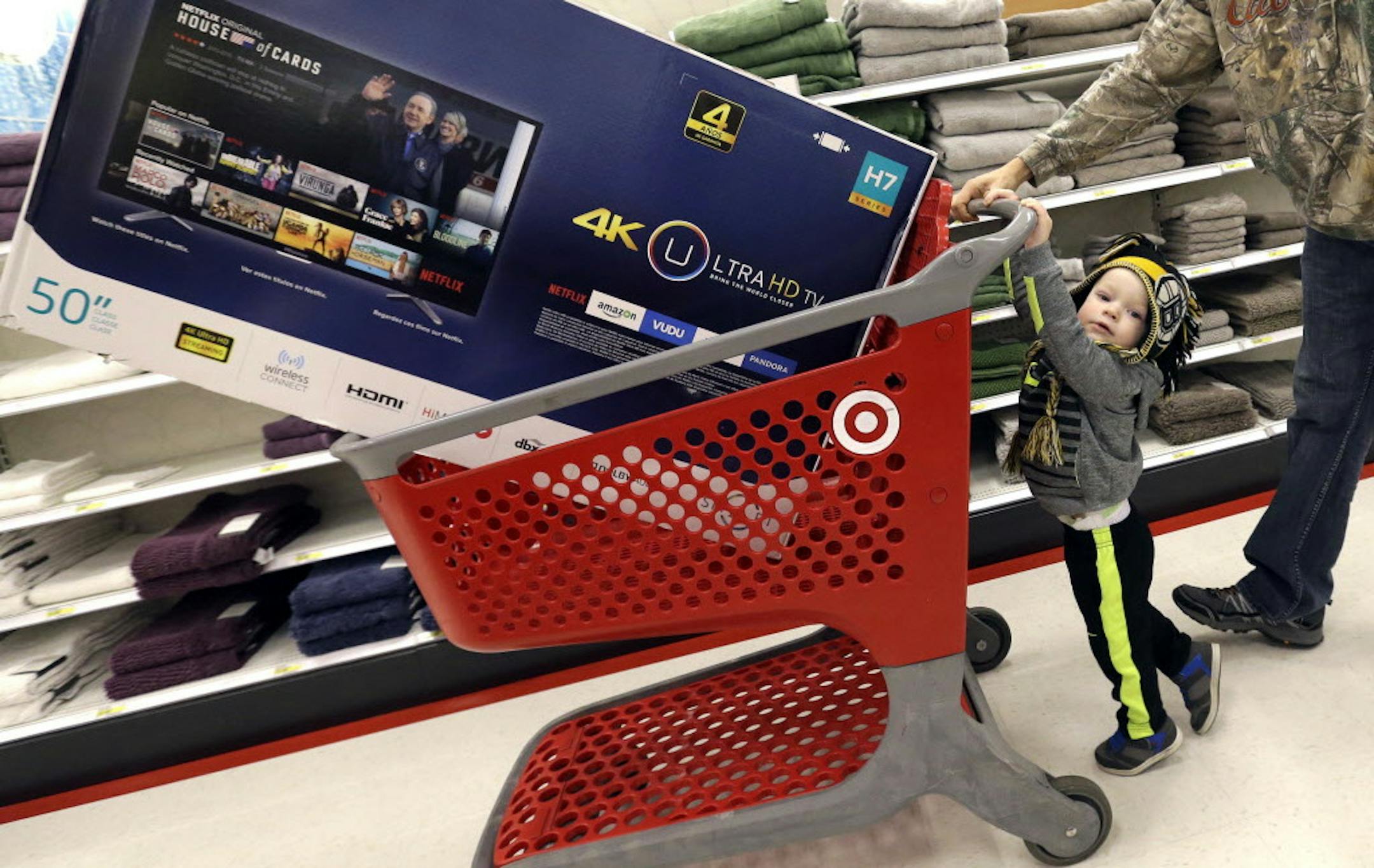 FILE - In this Friday, Nov. 25, 2016, file photo, Hunter Harvey helps his dad, C.J., wheel a big screen TV at Target, in Wilmington, Mass. The U.S. economy grew at a 3.5 percent annual rate in the July-September quarter, the fastest pace in two years and more than the government had previously estimated. But the growth spurt isnít expected to last. The gain in the gross domestic product, the economyís total output of goods and services, came from added strength in consumer spending, bu