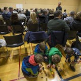 A group of children patiently played with dinosaurs during a GOP precinct caucus for precinct 3 at South View Middle School on March 1, 2016, in Edina, Minn.