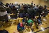 A group of children patiently played with dinosaurs during a GOP precinct caucus for precinct 3 at South View Middle School on March 1, 2016, in Edina, Minn.