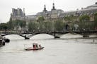 With the Louvre museum in the background, Firemen patrol the flooding Seine river in Paris, France Friday June 3, 2016. Both the Louvre and Orsay muse
