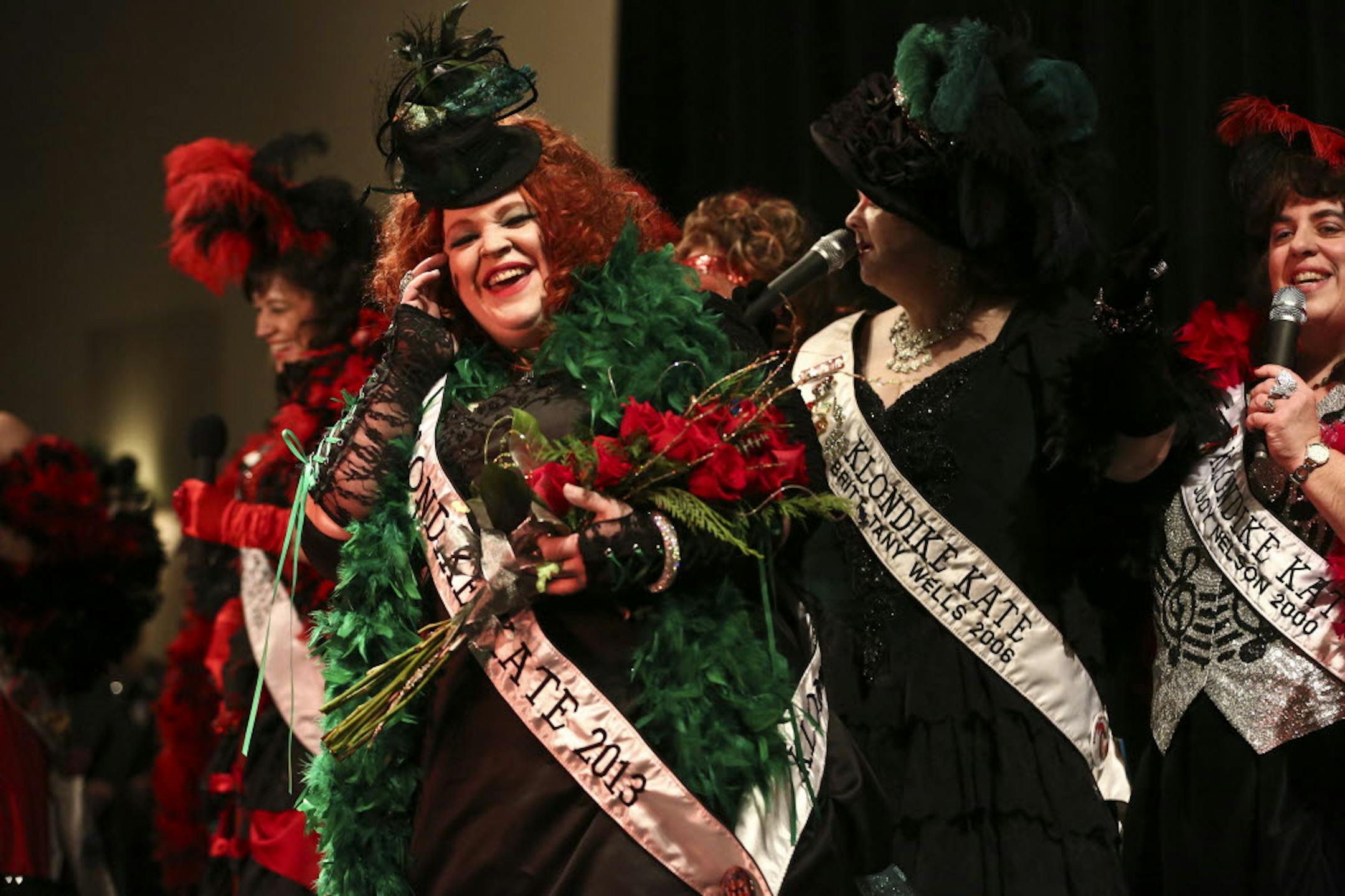 Anita Mack, splendid in green feathers, took the red roses Wednesday night as the new Klondike Kate. She was flanked by some of her predecessors.