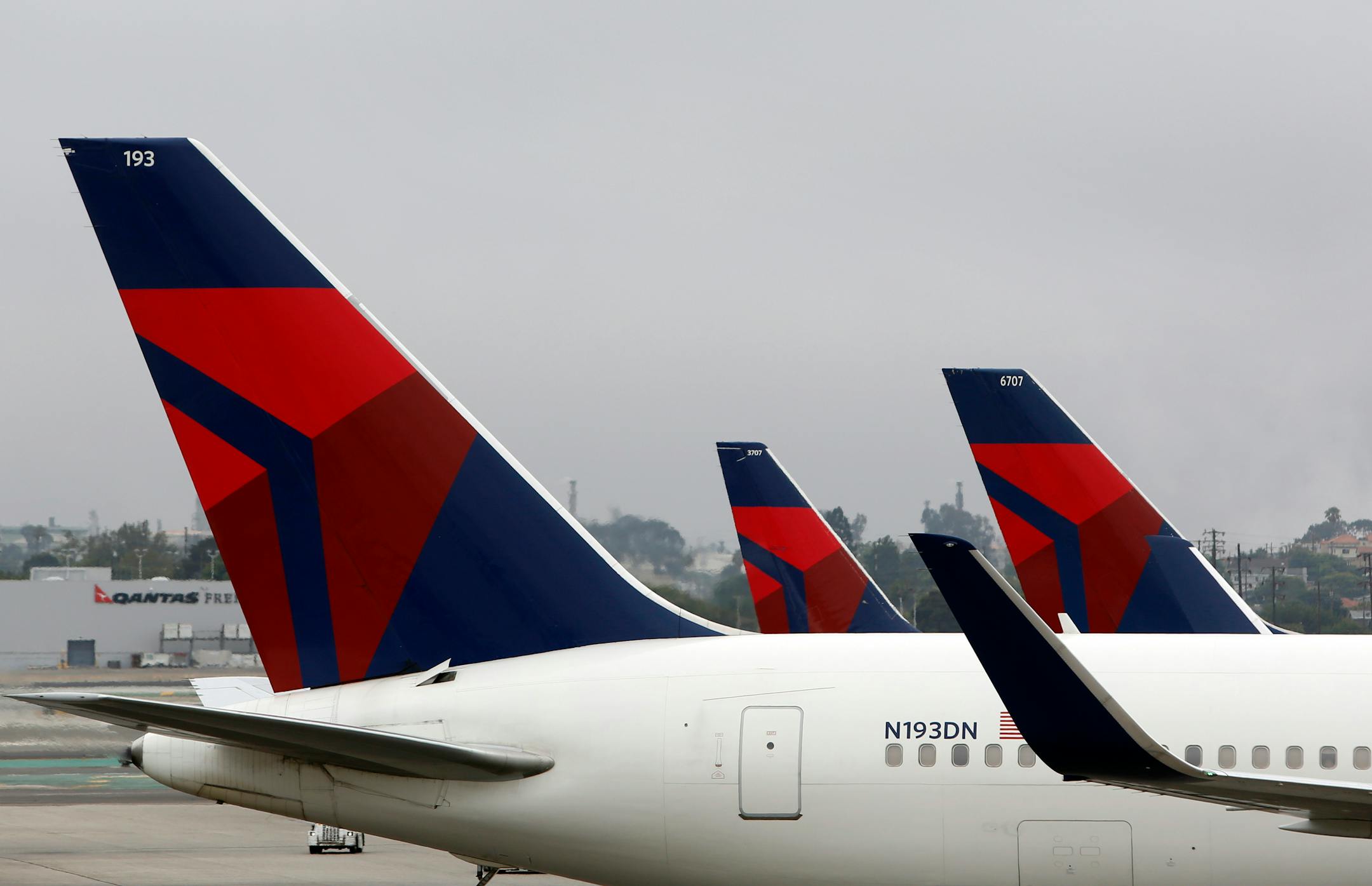 A Delta Air Lines Inc. Boeing 767-332/ER plane, front, sits on the tarmac at Los Angeles International Airport (LAX) in Los Angeles, California, U.S., on Wednesday, July 24, 2013. Delta Air Lines Inc. and US Airways Group Inc. advanced in New York trading after reporting second-quarter earnings that exceeded analysts� estimates, helped by declining jet-fuel prices. Photographer: Patrick T. Fallon/Bloomberg